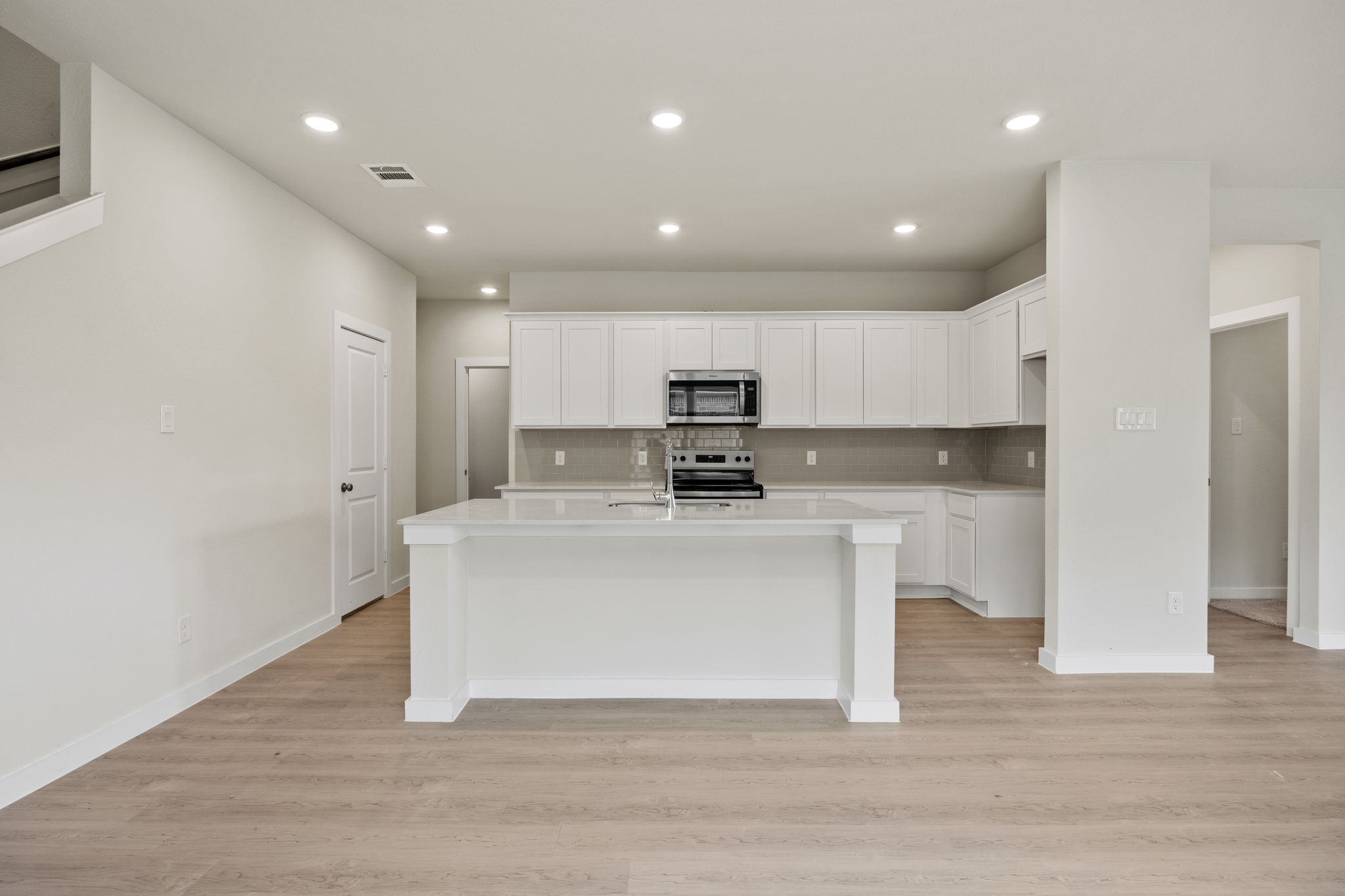 A kitchen with white cabinets.