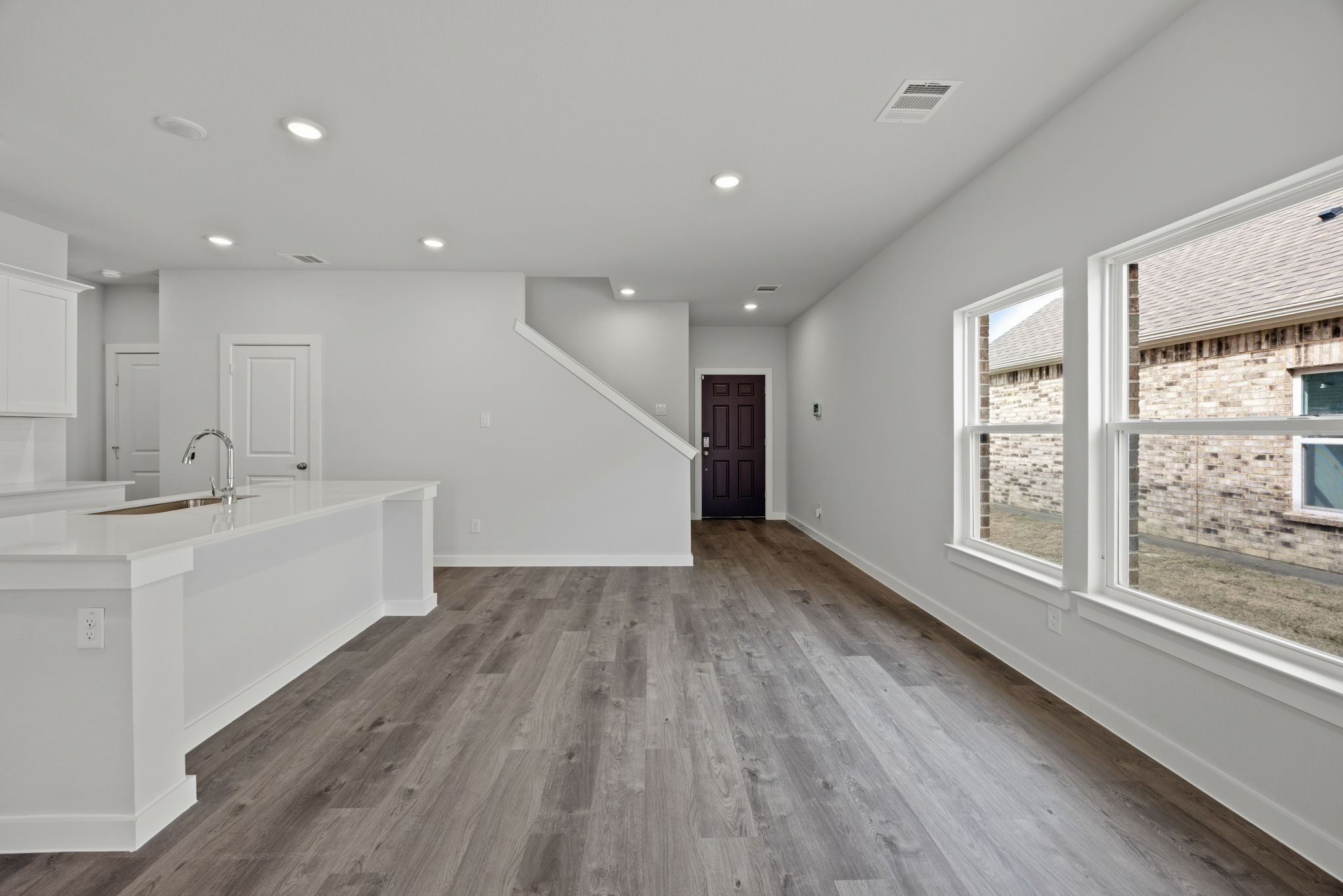 A large white bathroom with a wood floor.