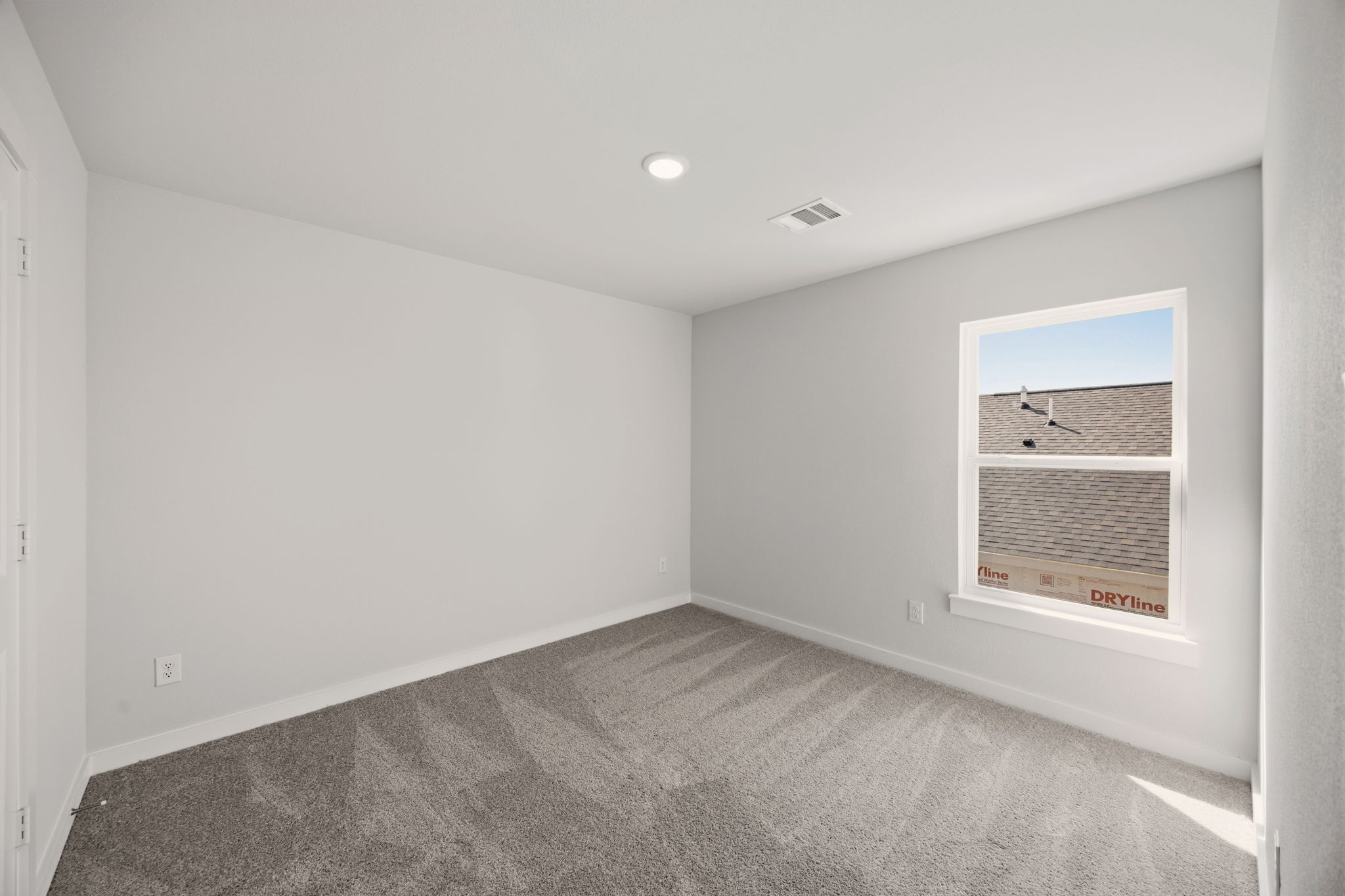 A room with a window and a rug.