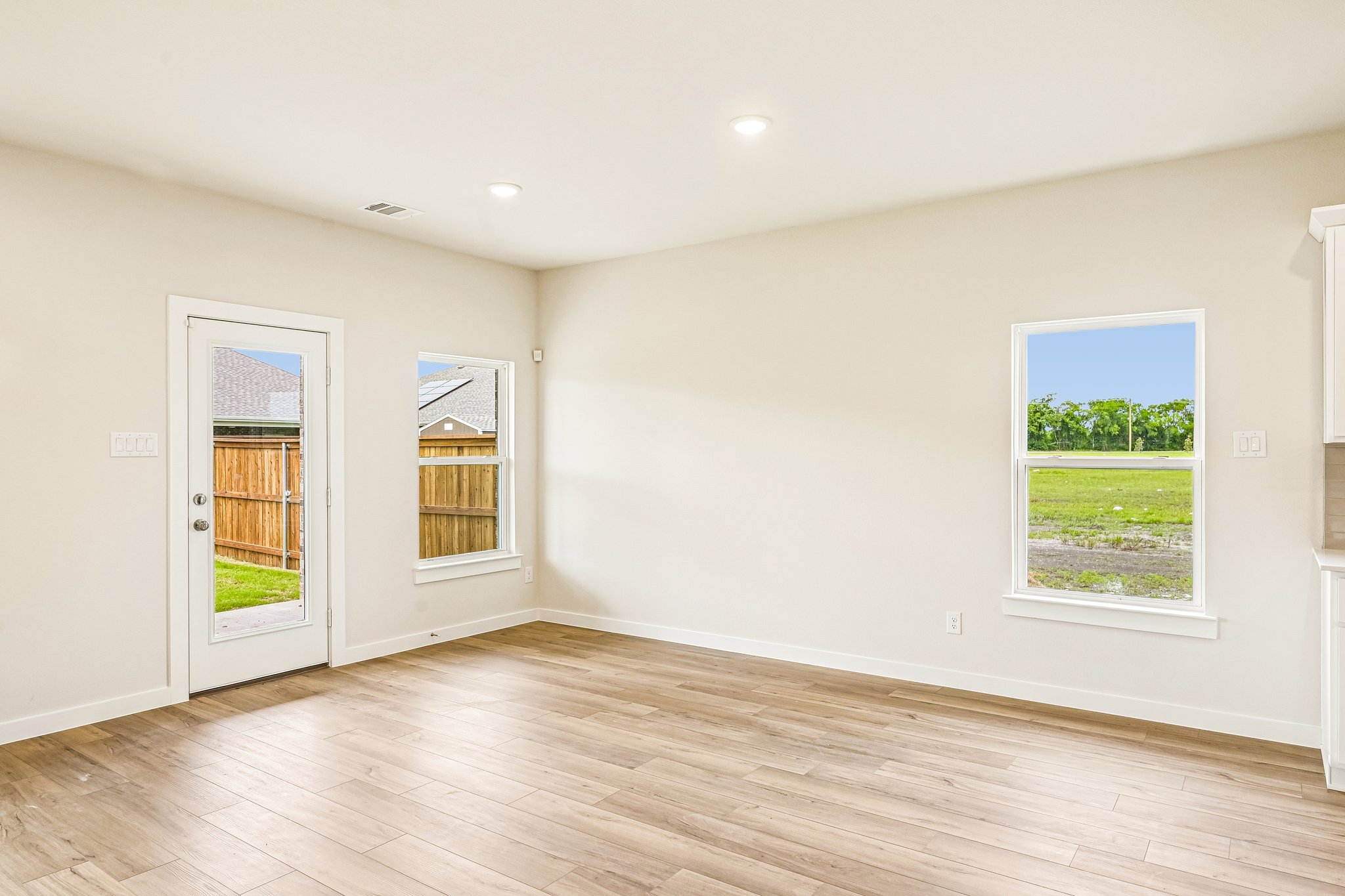 A room with a wood floor and windows.