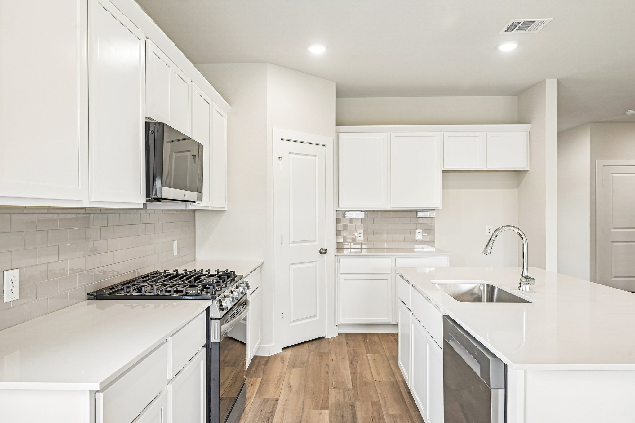 A kitchen with white cabinets.