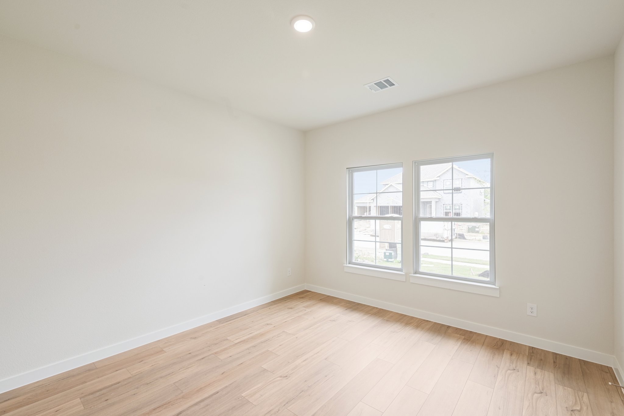 A room with a wood floor and a window.