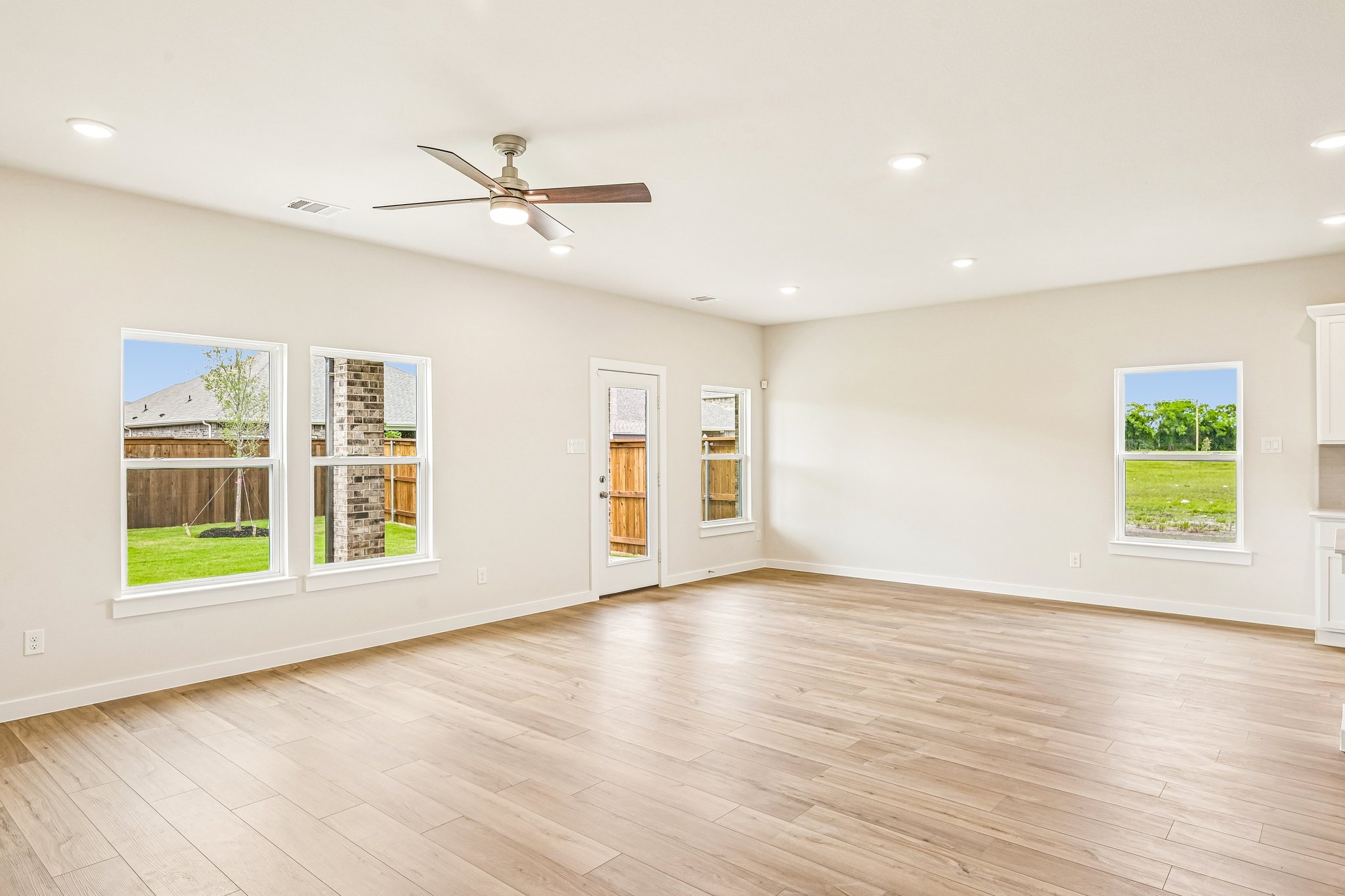 A room with a wood floor and a ceiling fan.