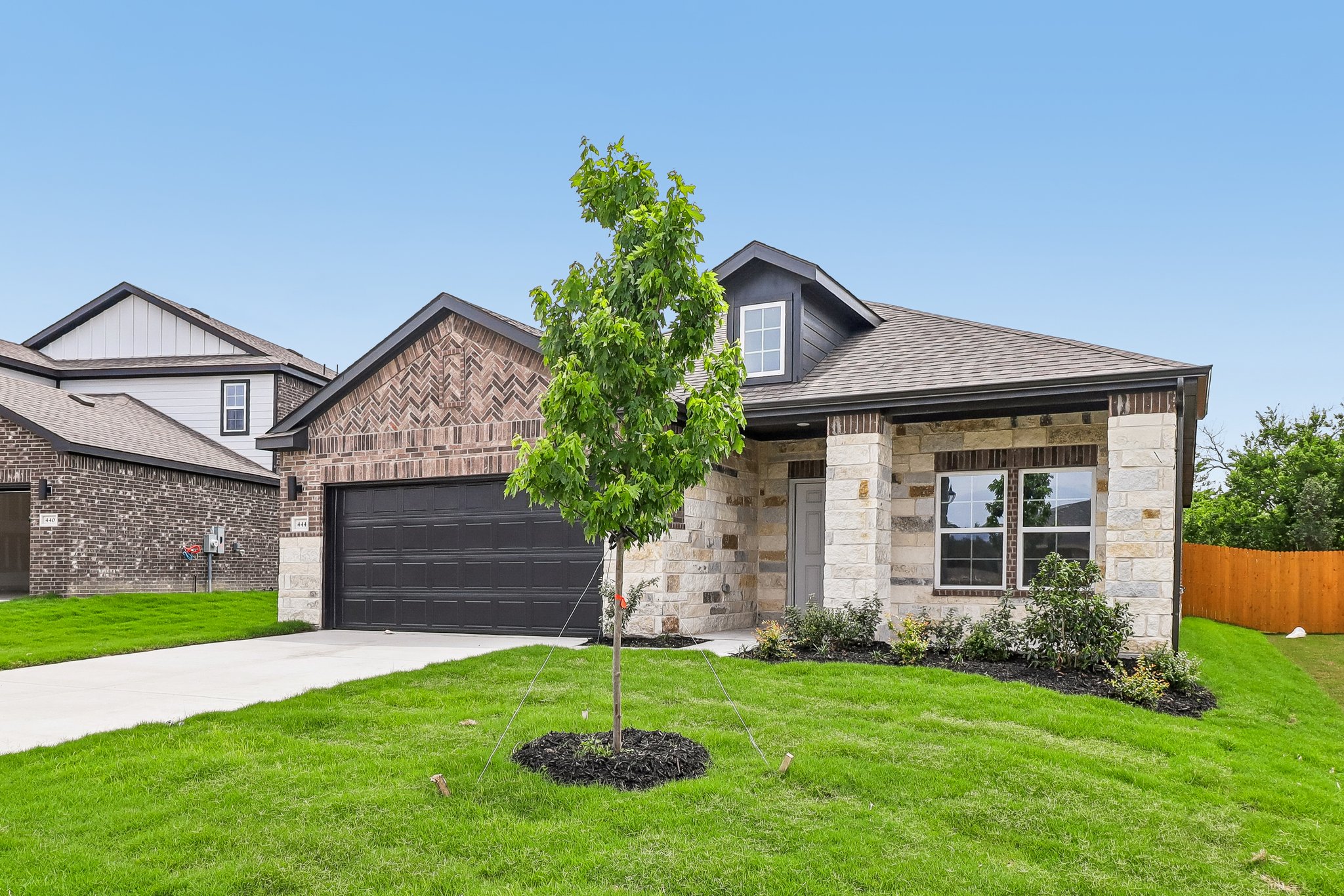 A house with a tree in the front yard.