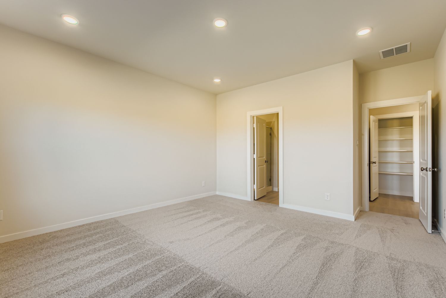 A room with a carpet and a door.