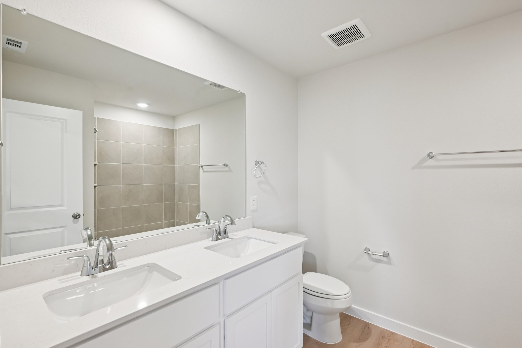 A bathroom with a sink toilet and mirror.