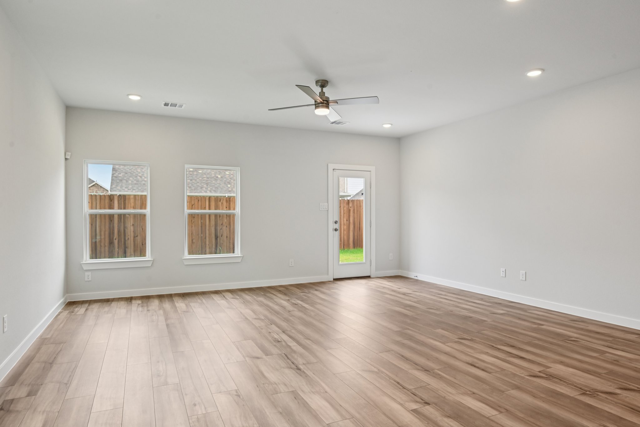 A room with a wood floor and a ceiling fan.