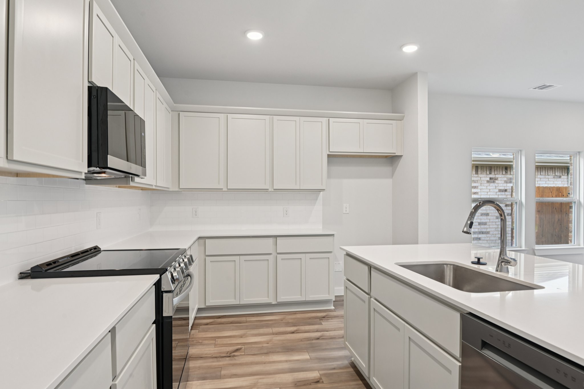 A kitchen with white cabinets.
