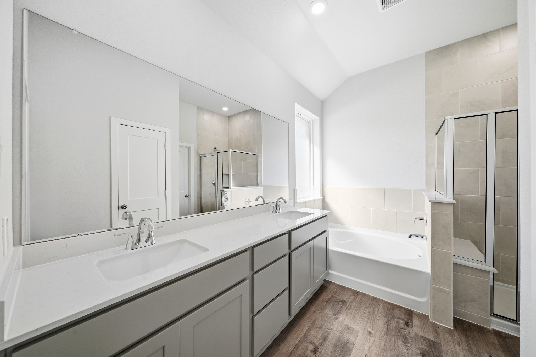 A bathroom with a tub sink and a mirror.