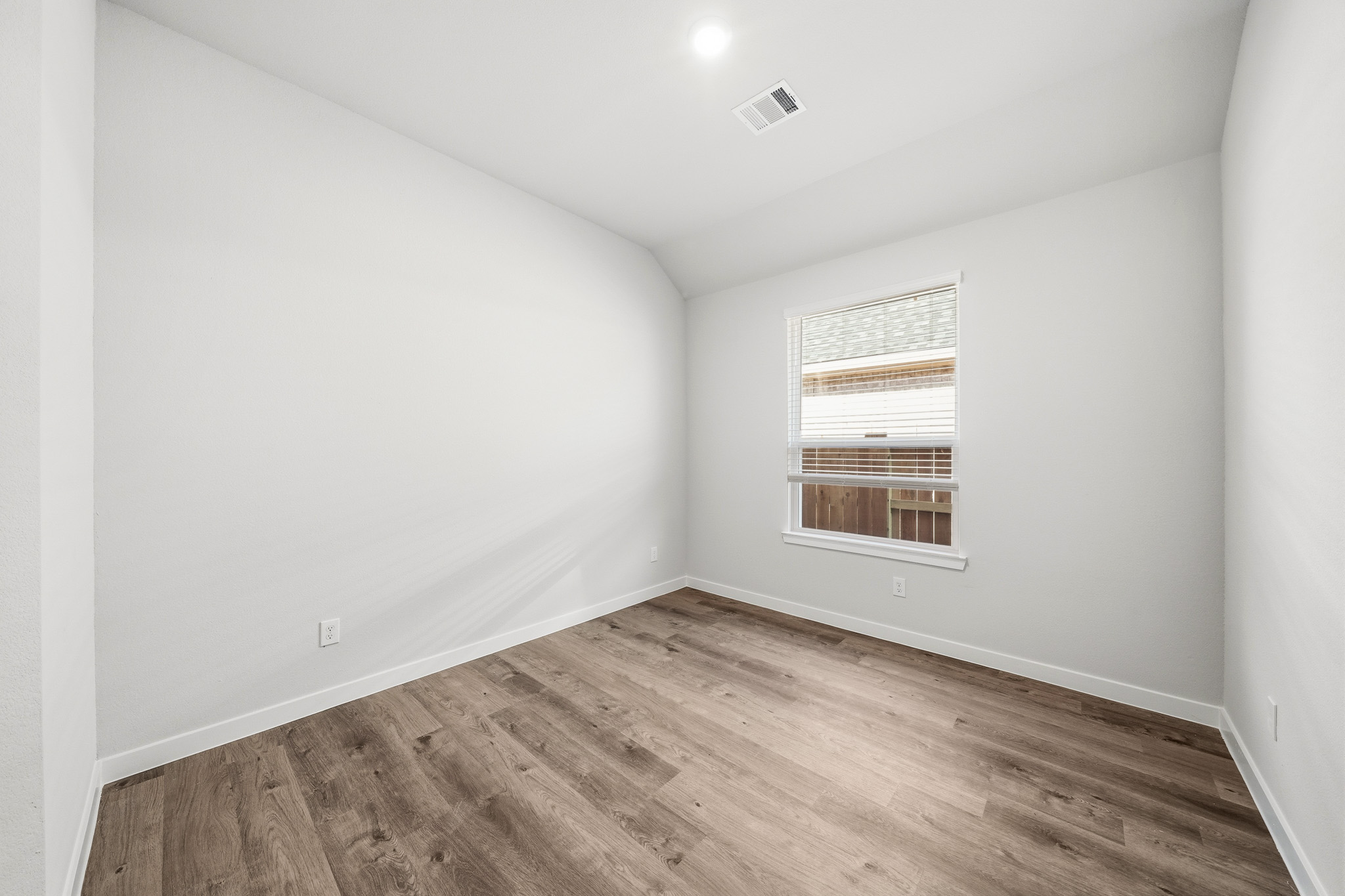 A room with a wood floor and a window.