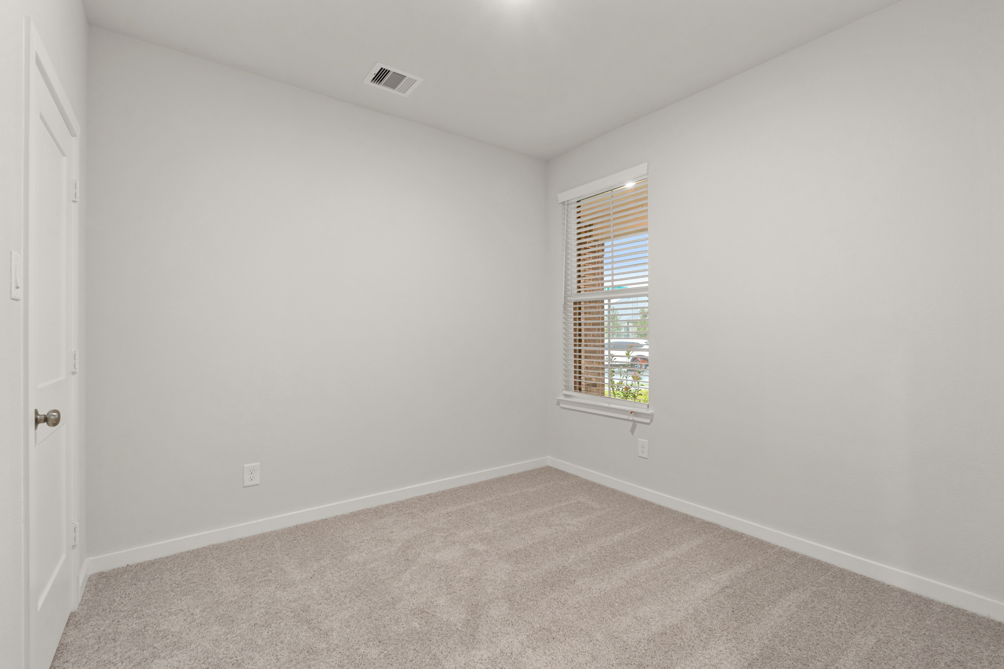 A room with a window and carpet.