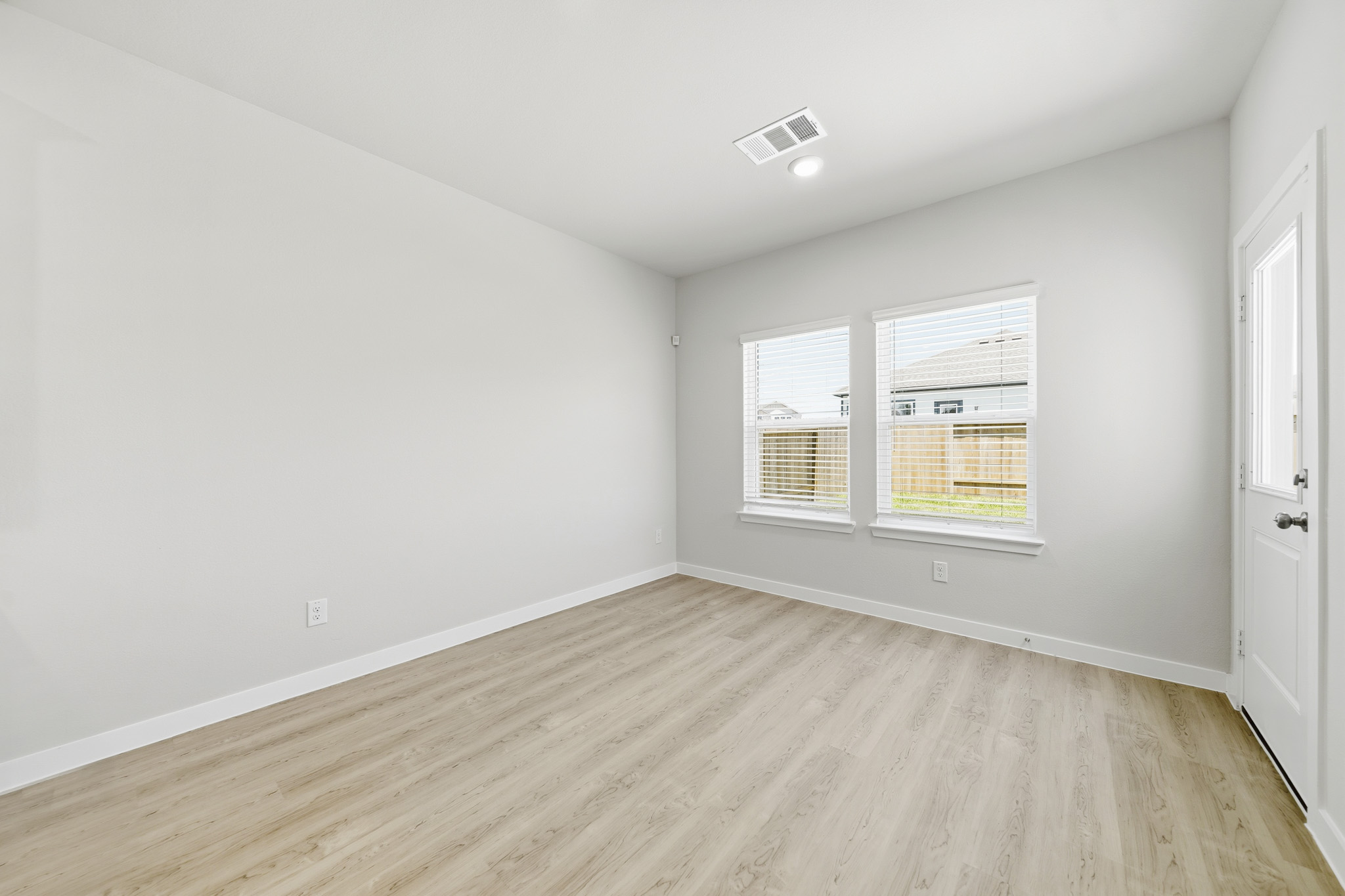 A room with a wood floor and windows.