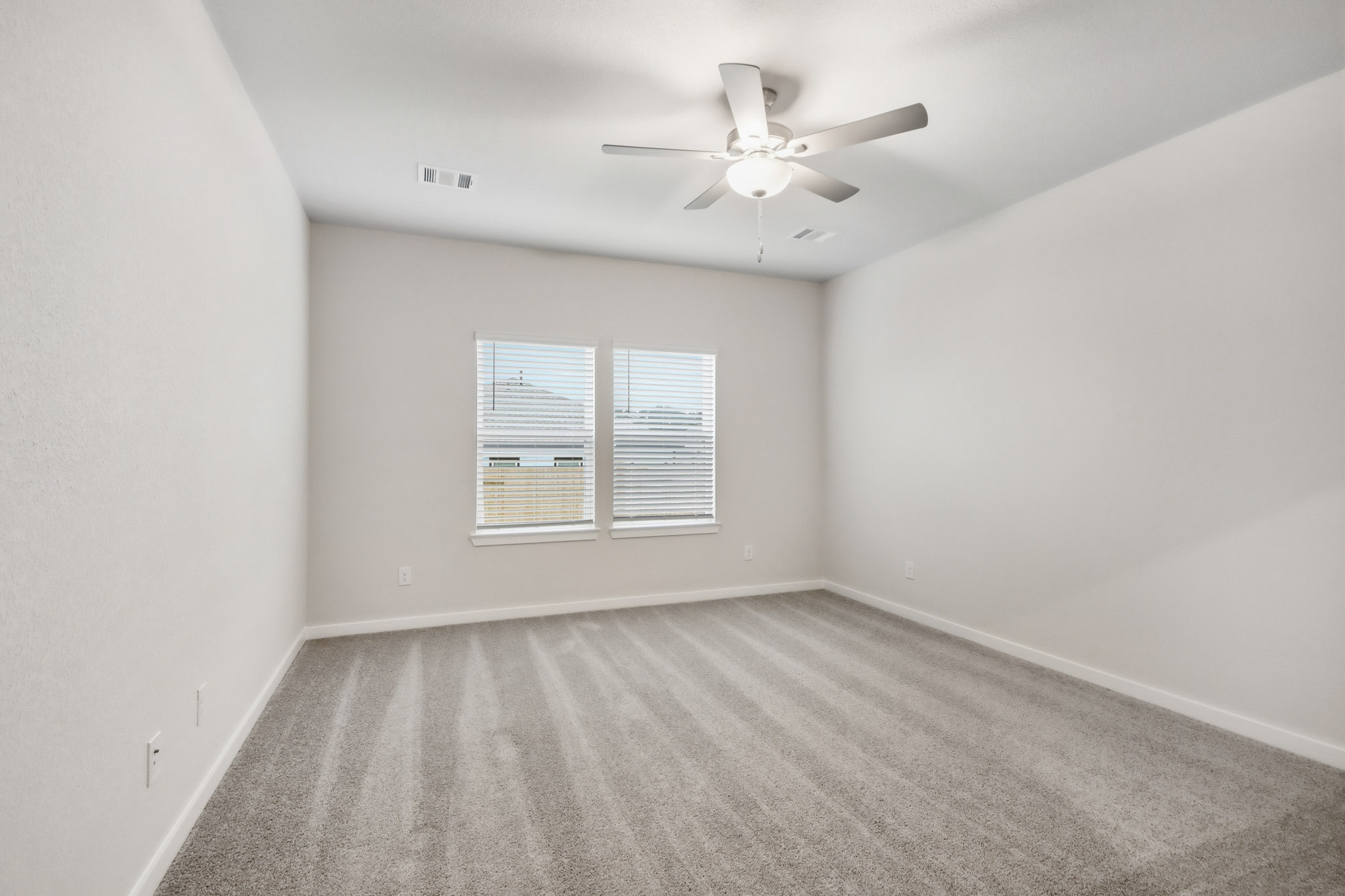 A room with a ceiling fan and a window.