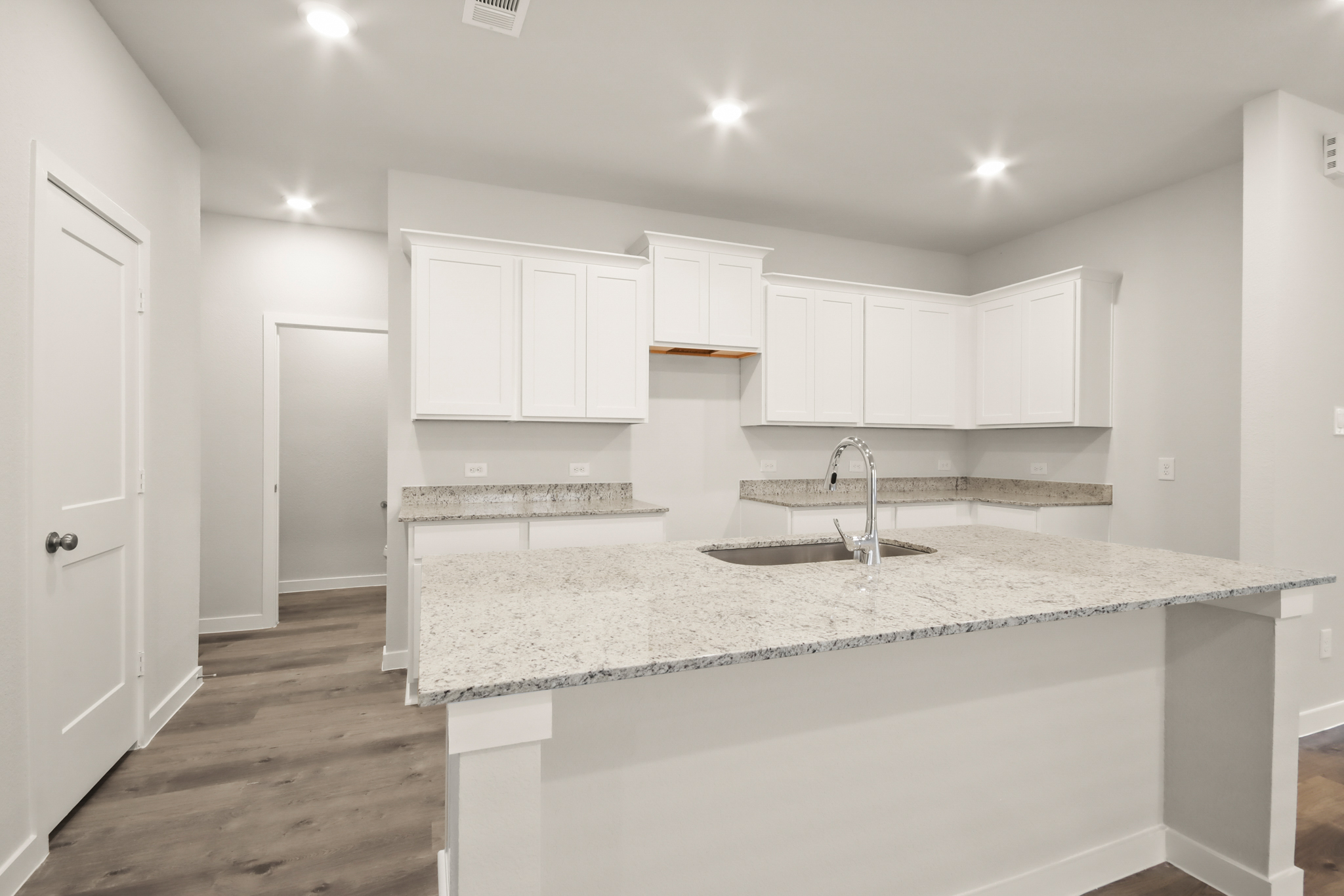 A kitchen with white cabinets.