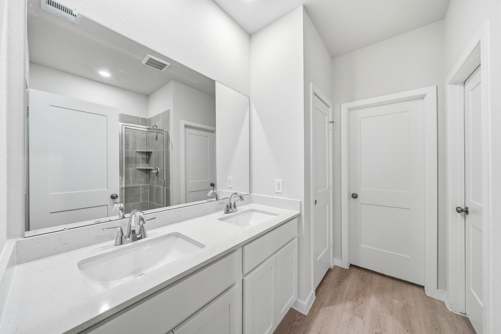 A bathroom with white cabinets.
