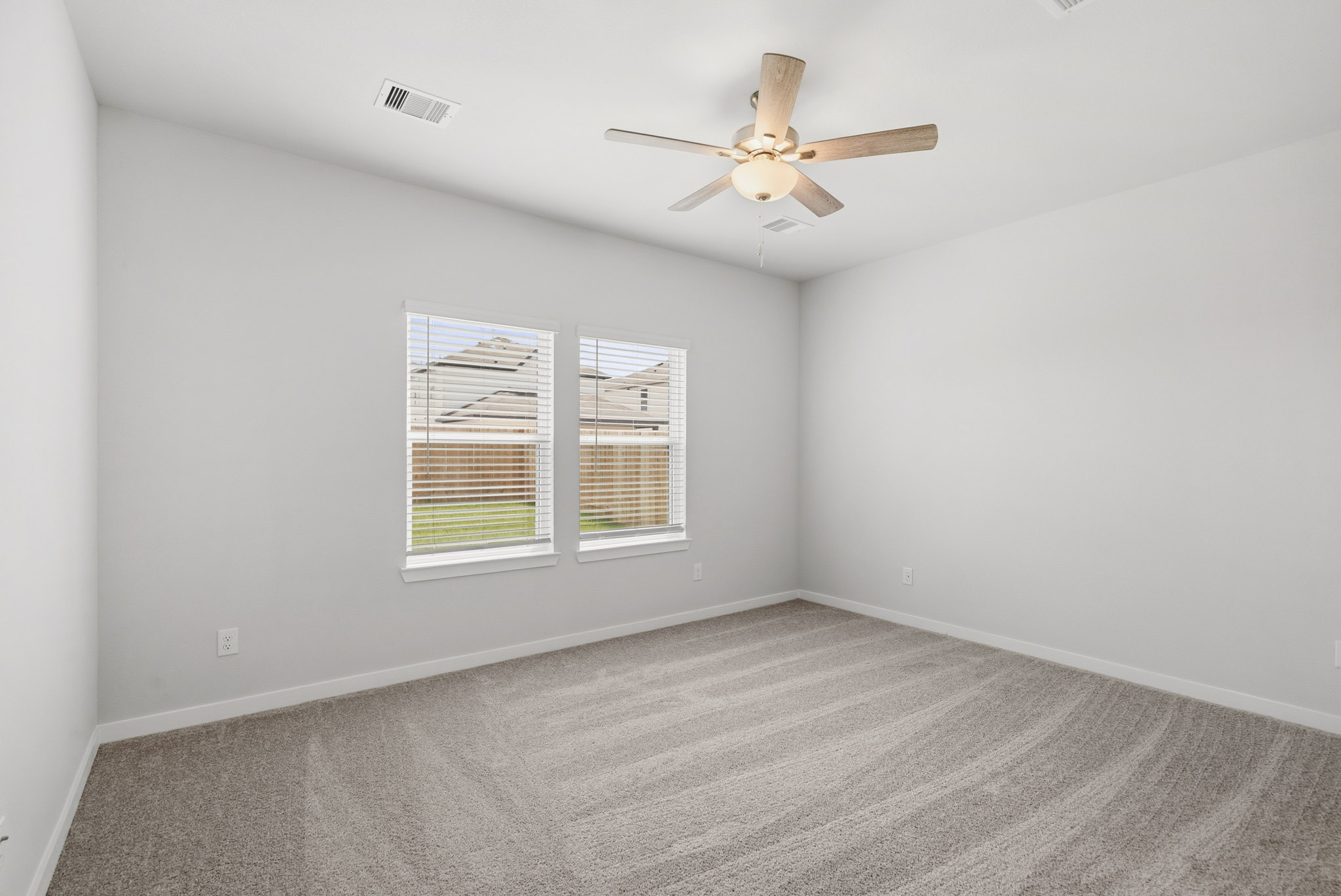 A room with a ceiling fan and a window.