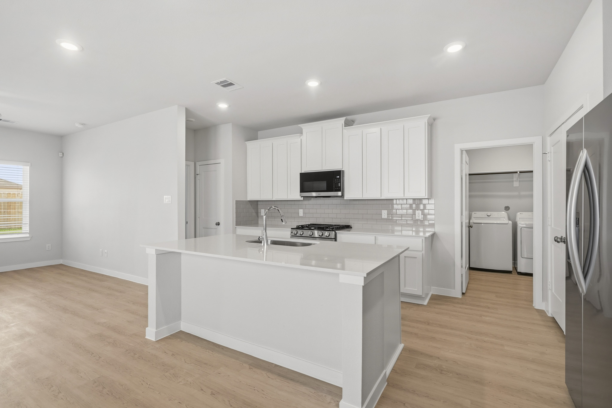 A kitchen with white cabinets.