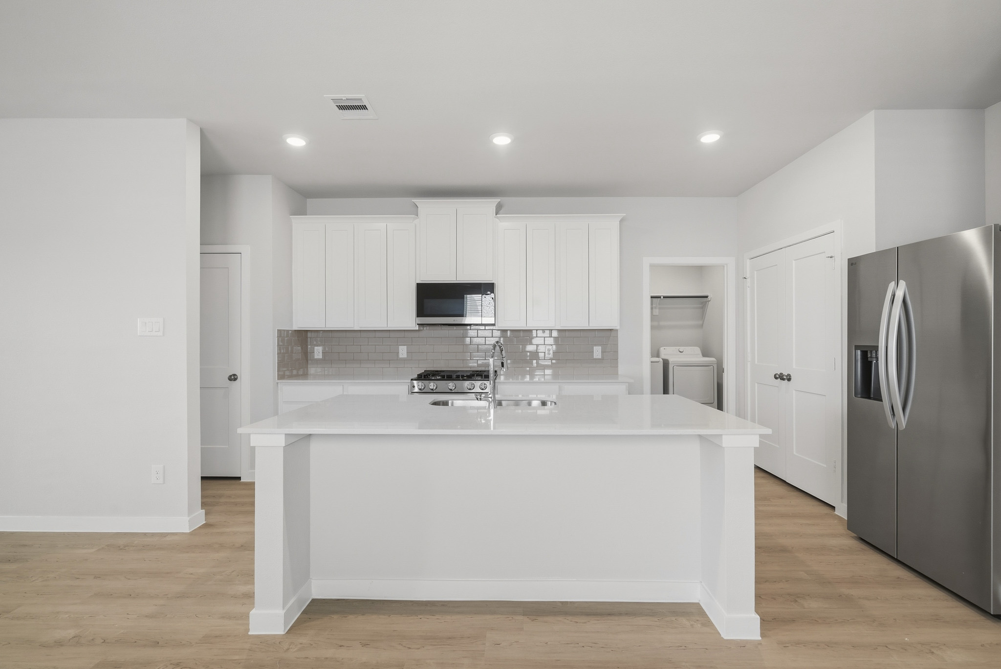 A kitchen with white cabinets.