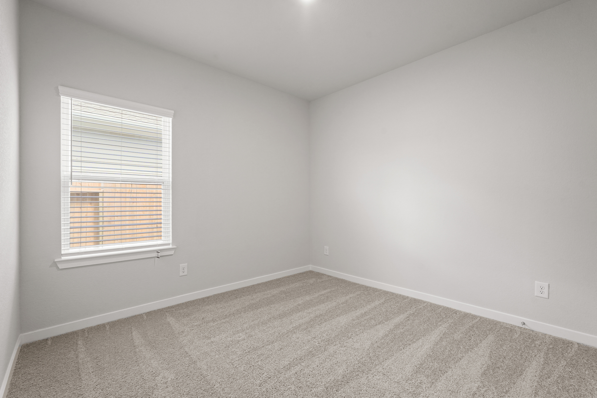 A room with a window and a carpet.