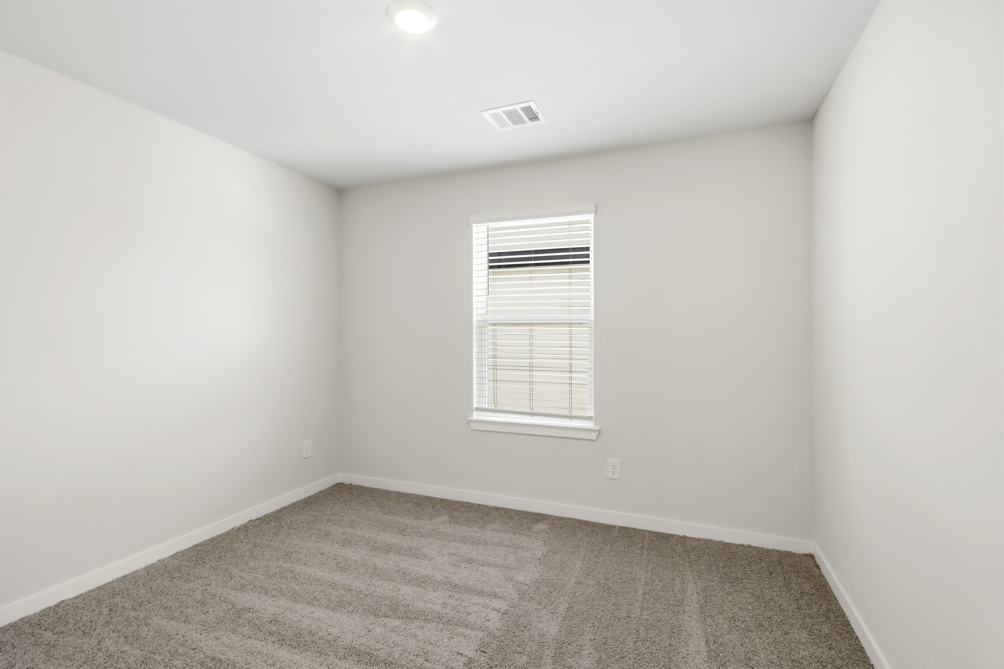 A room with a window and carpet.