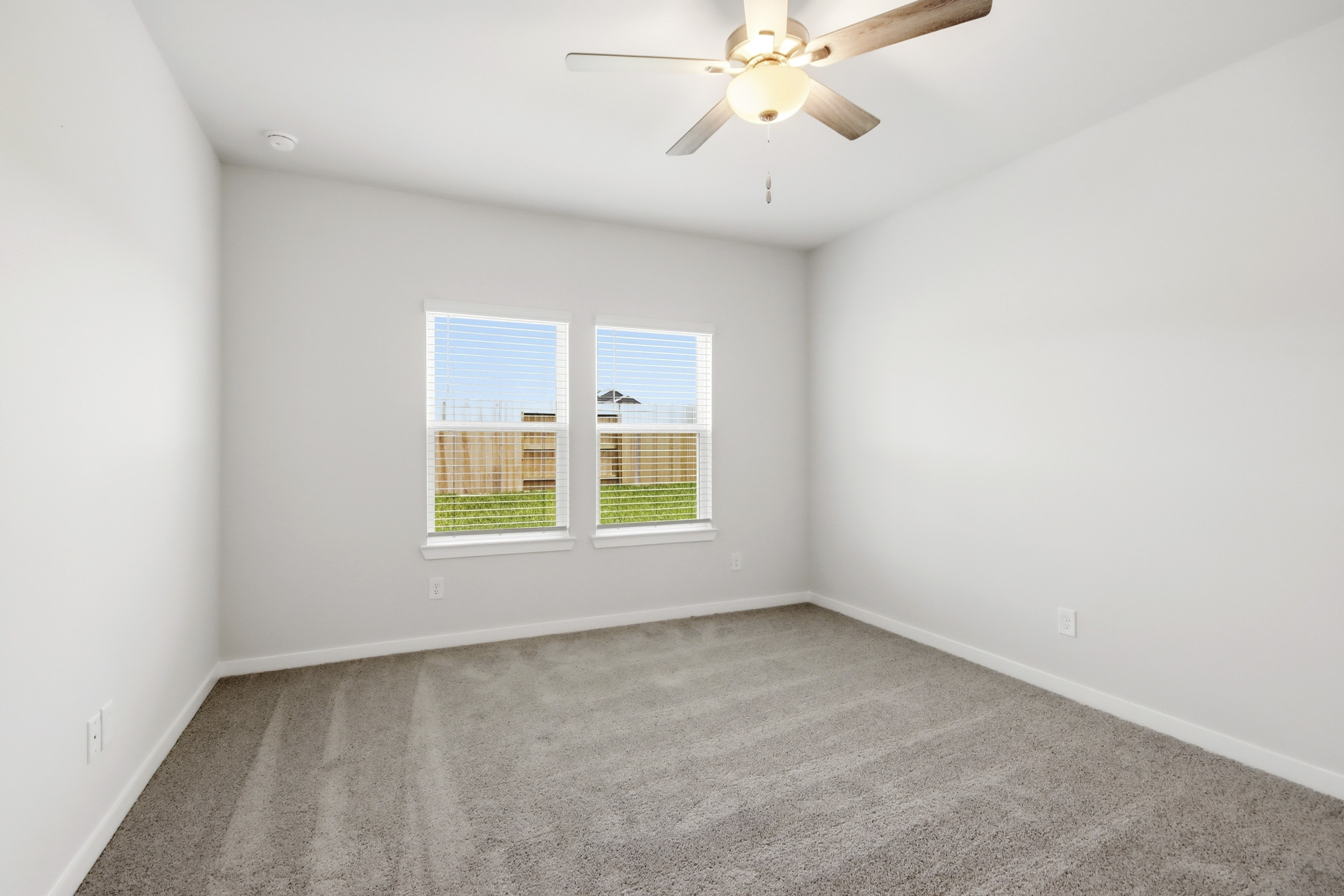 A room with a ceiling fan and a window.