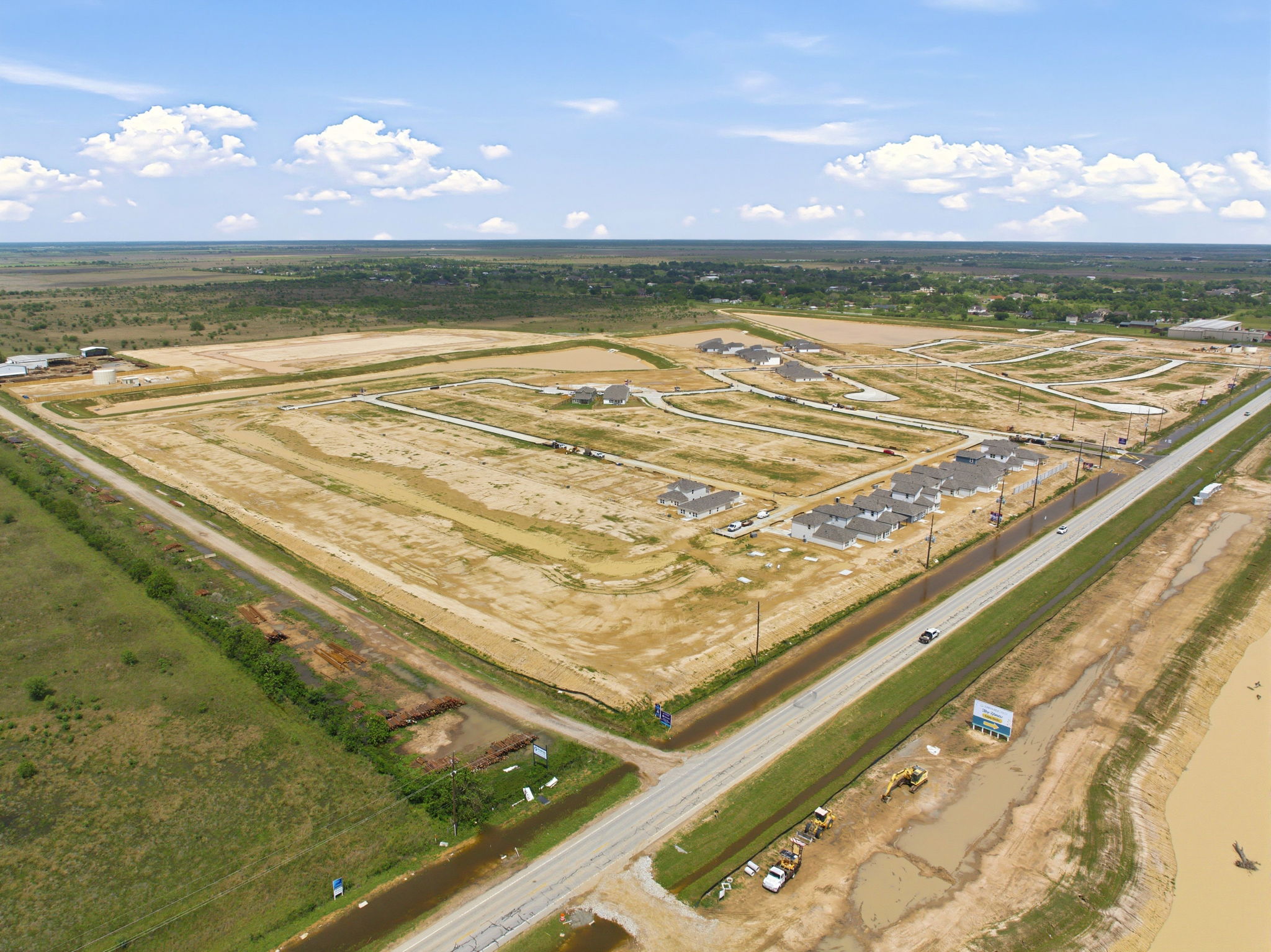 A large field with a few buildings.