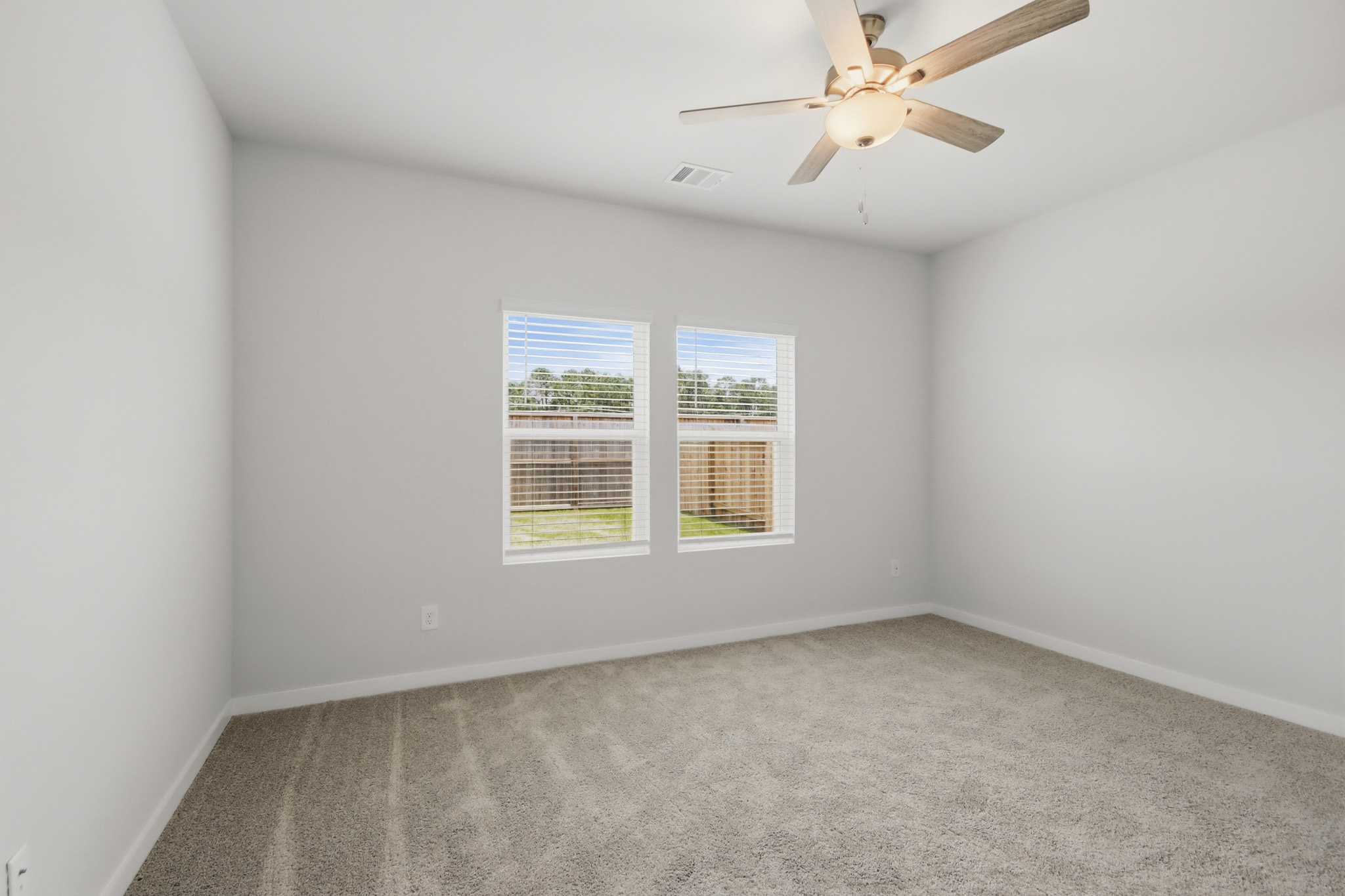 A room with a ceiling fan and a window.