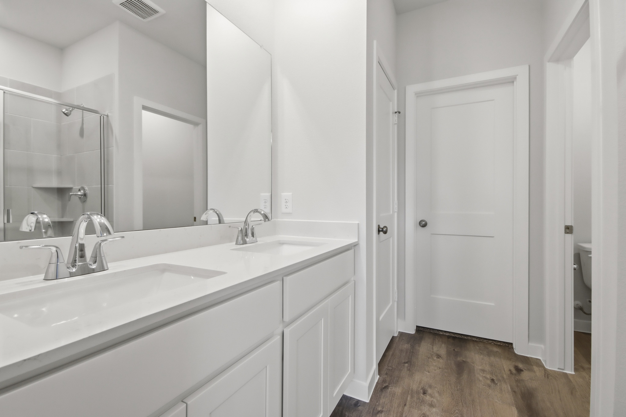 A bathroom with white cabinets.