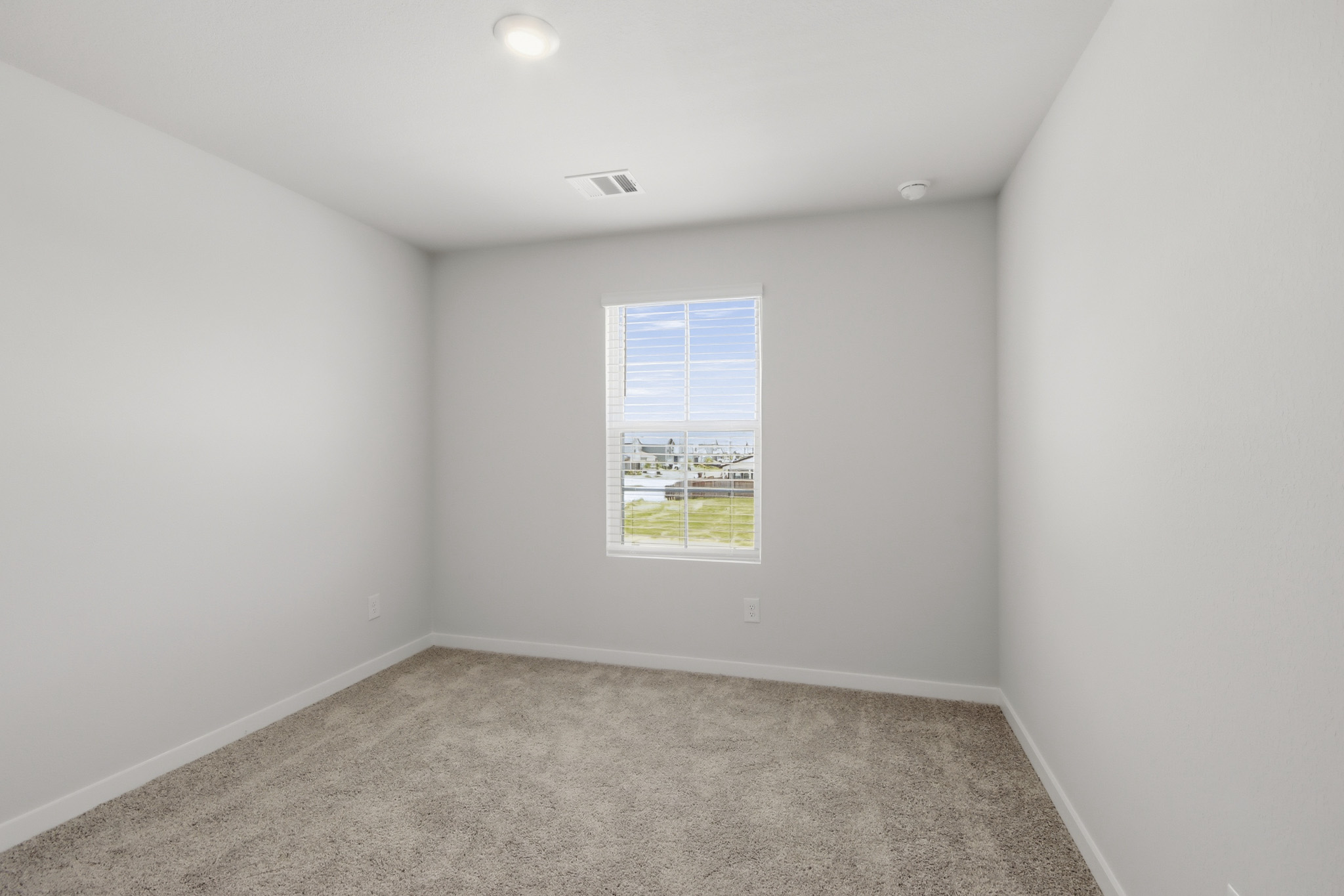 A room with a window and carpet.