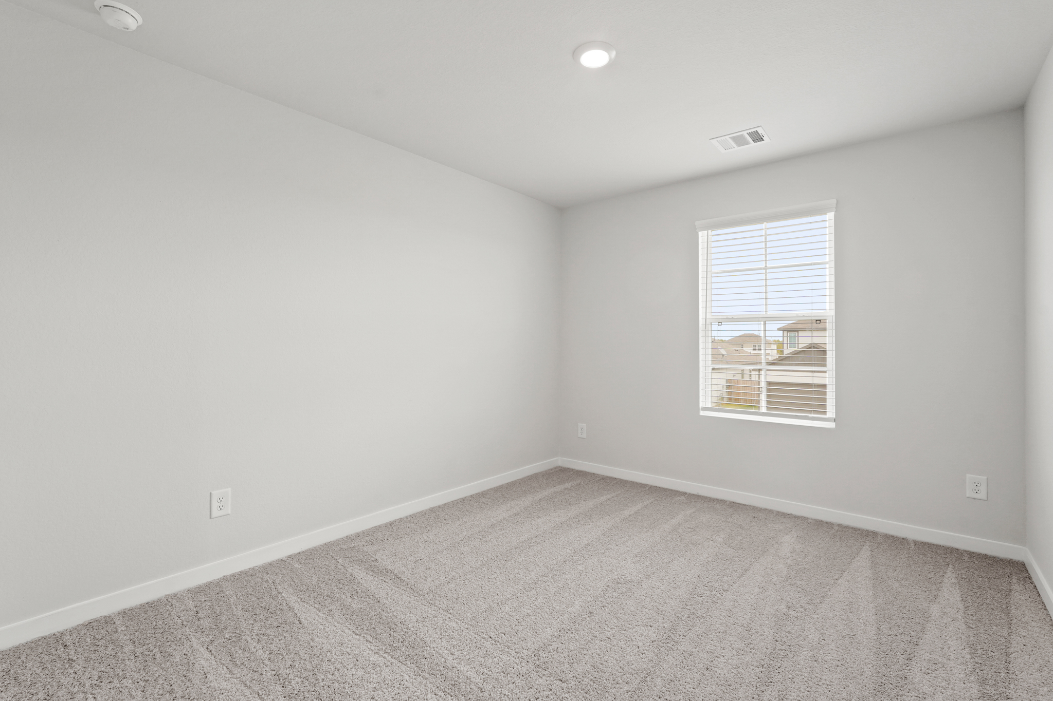 A room with a window and a carpet.