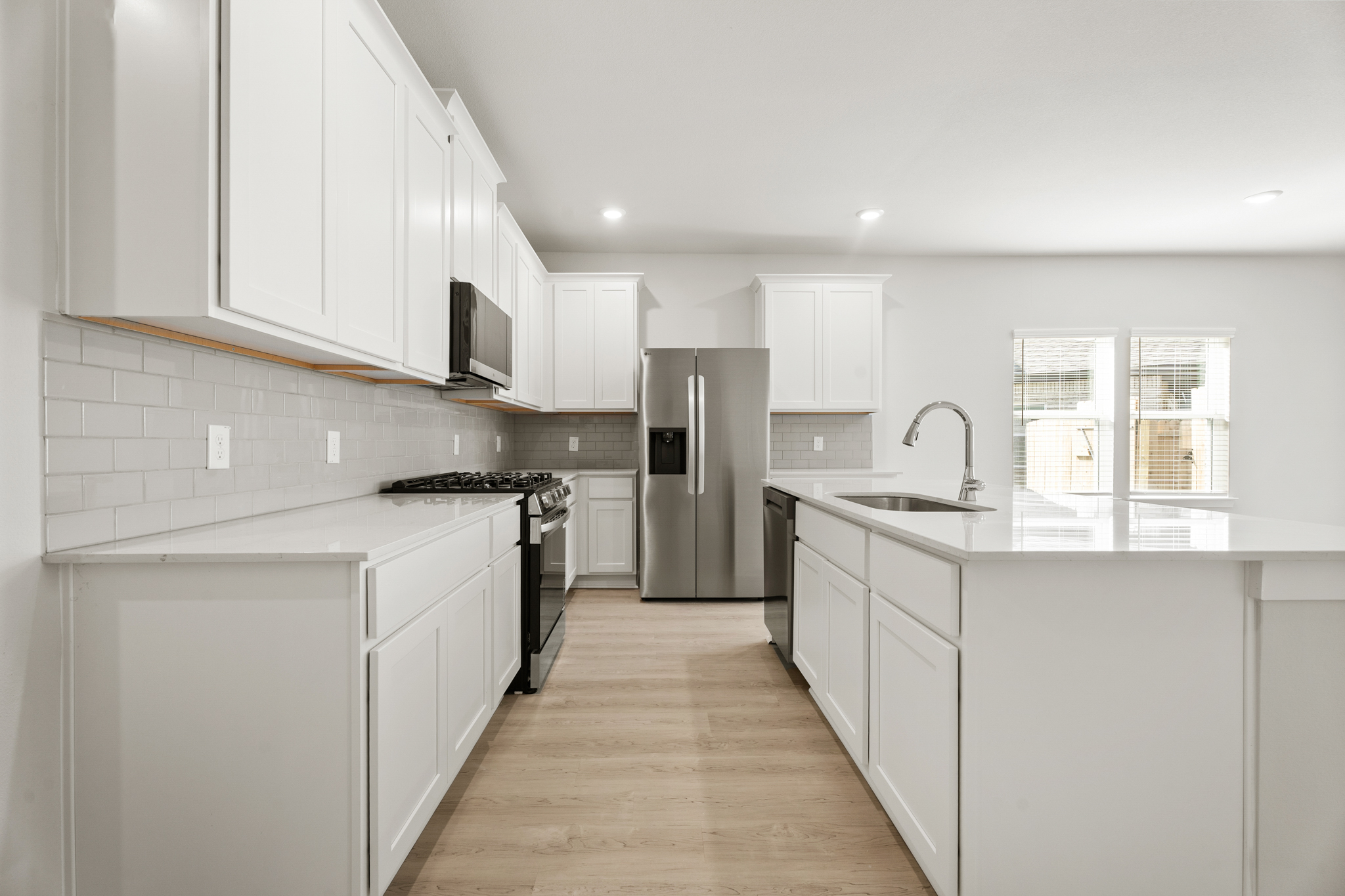 A kitchen with white cabinets.