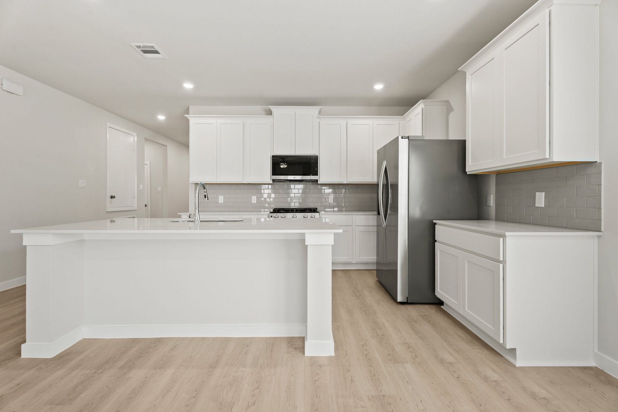 A kitchen with white cabinets.