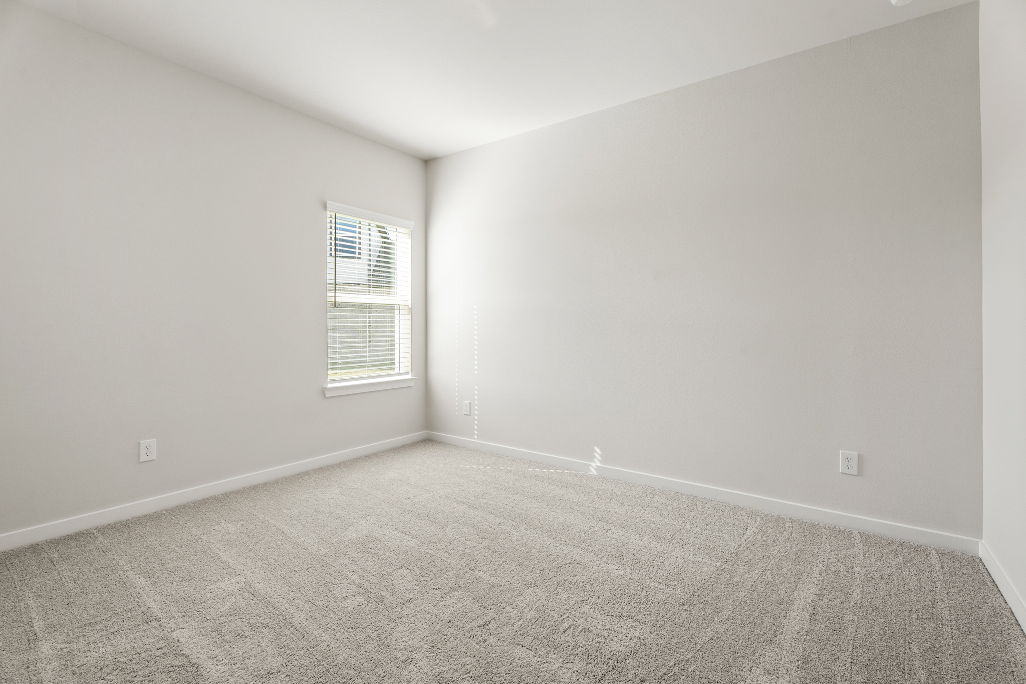 A room with a window and a carpet.