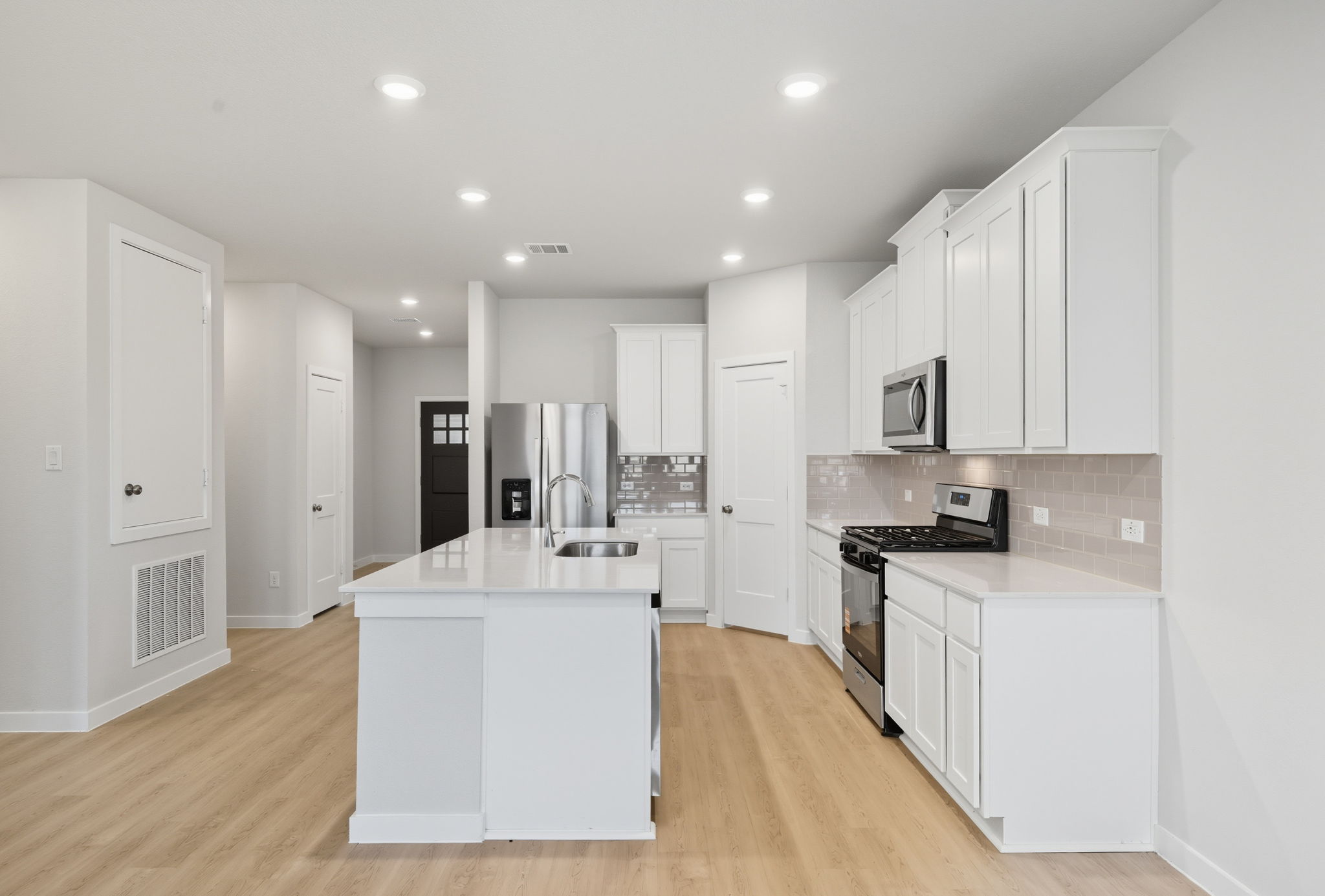 A kitchen with white cabinets.