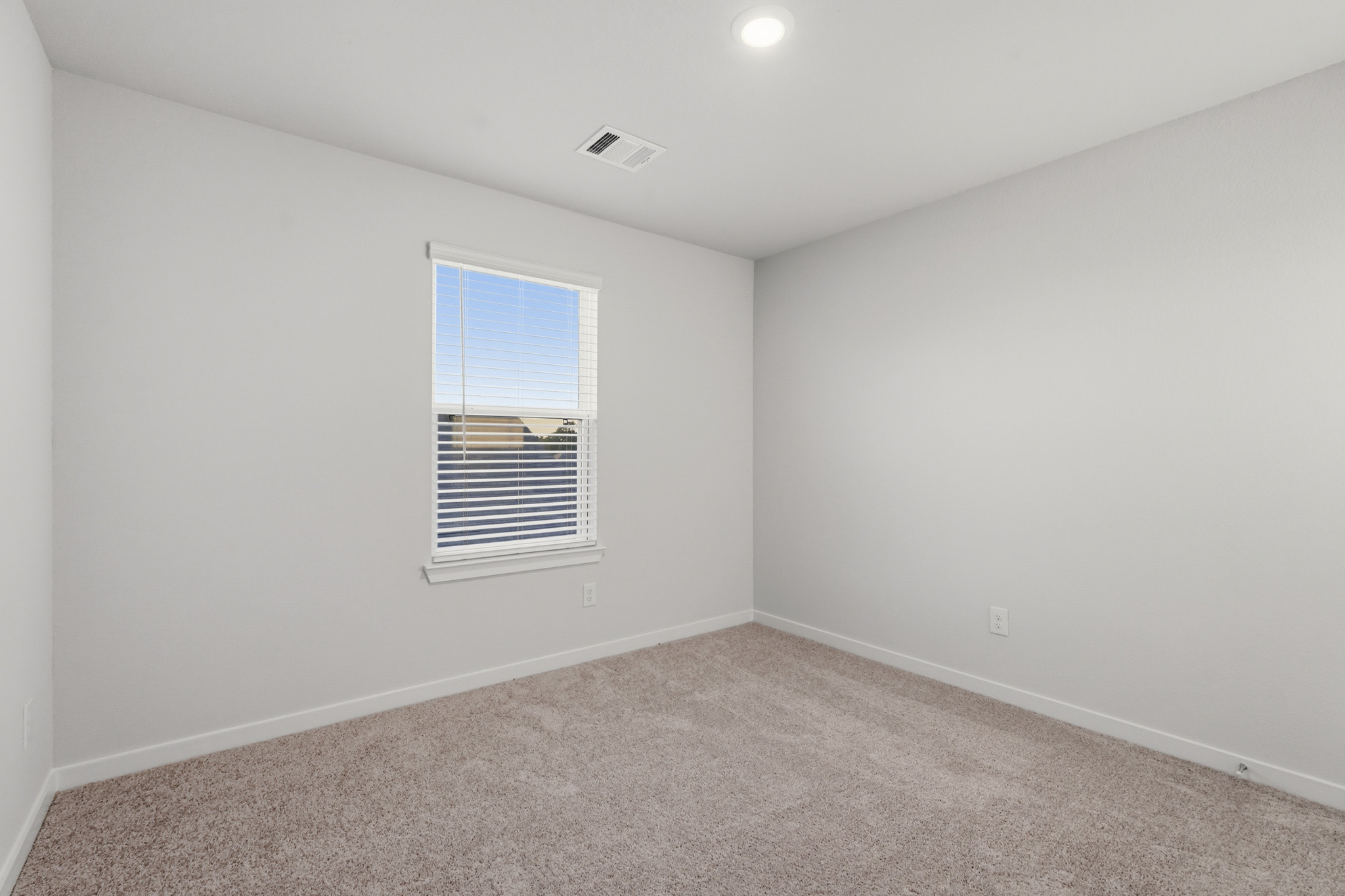 A room with a window and a carpet.