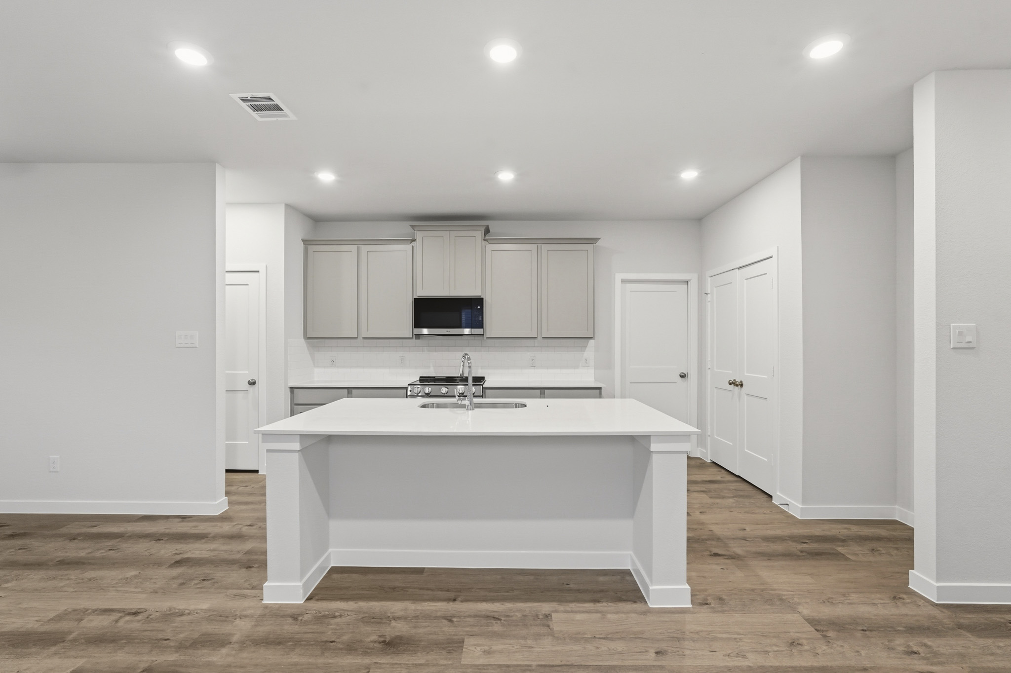 A kitchen with white cabinets.