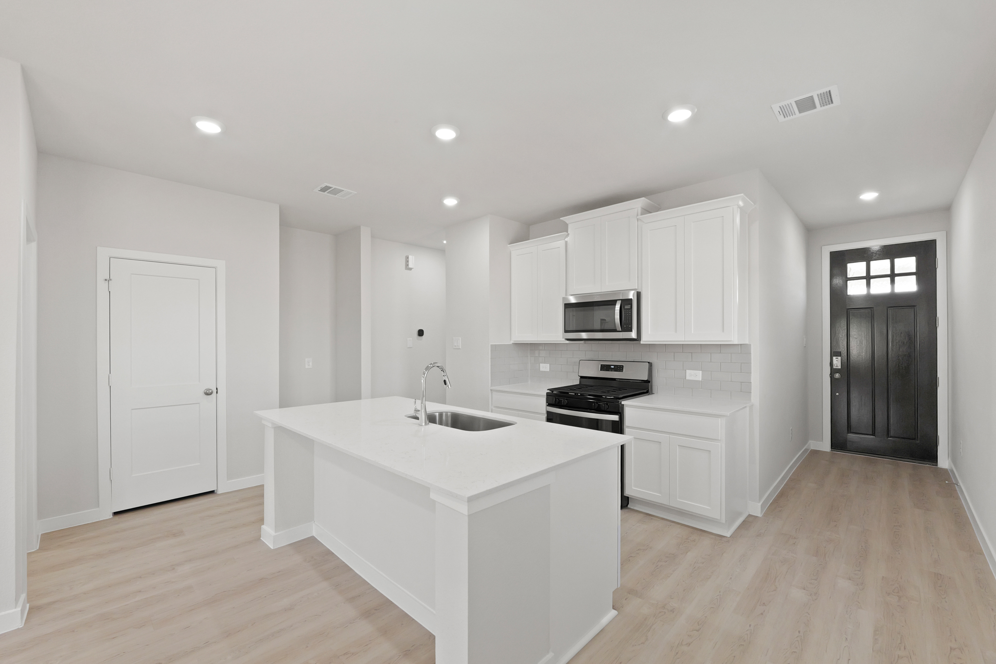 A kitchen with white cabinets.