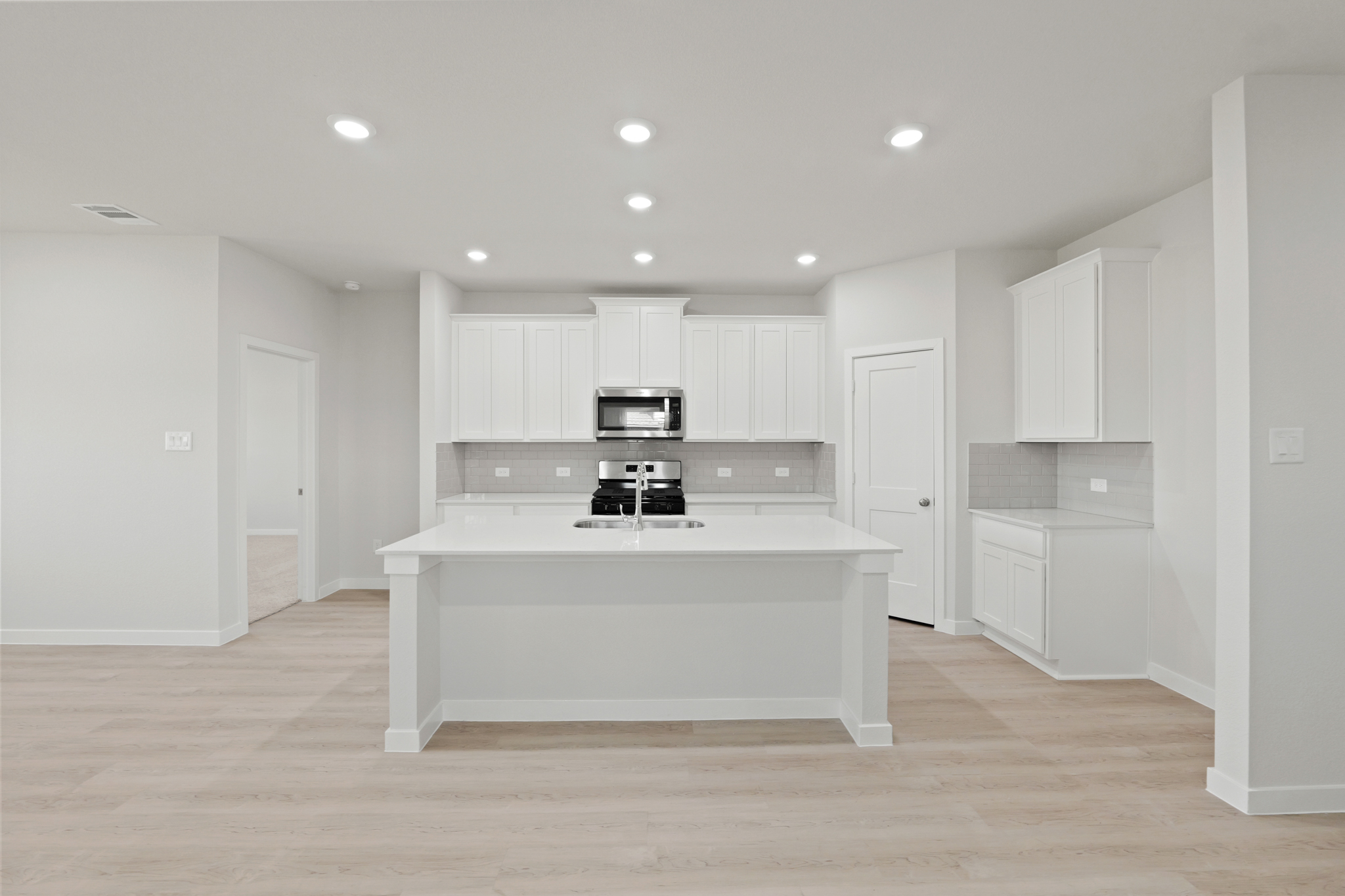 A kitchen with white cabinets.