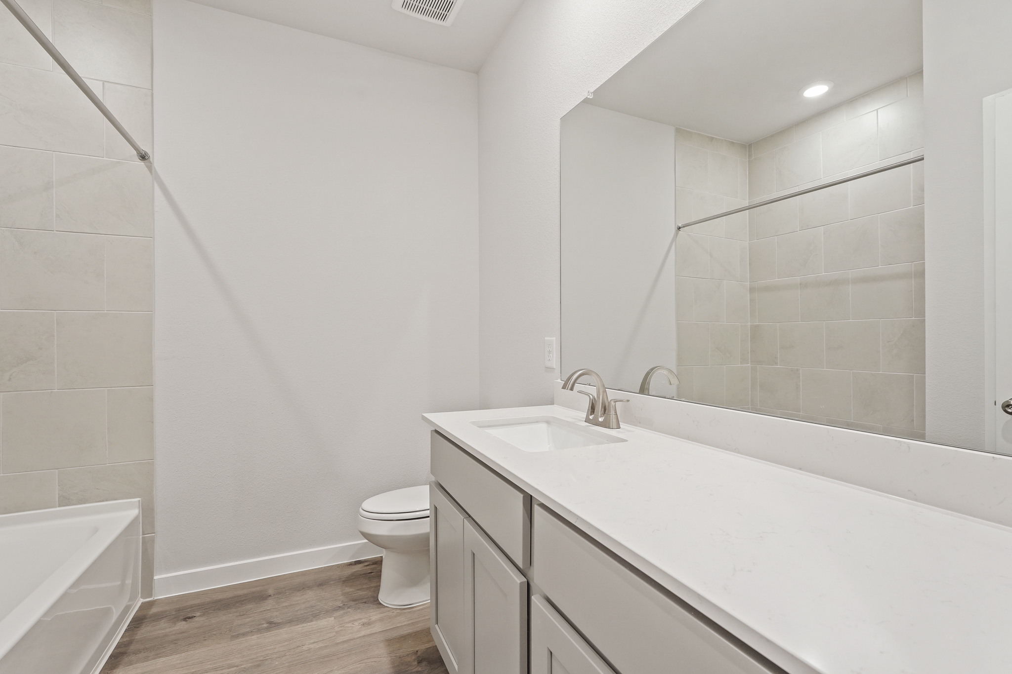 A bathroom with a tub sink and toilet.