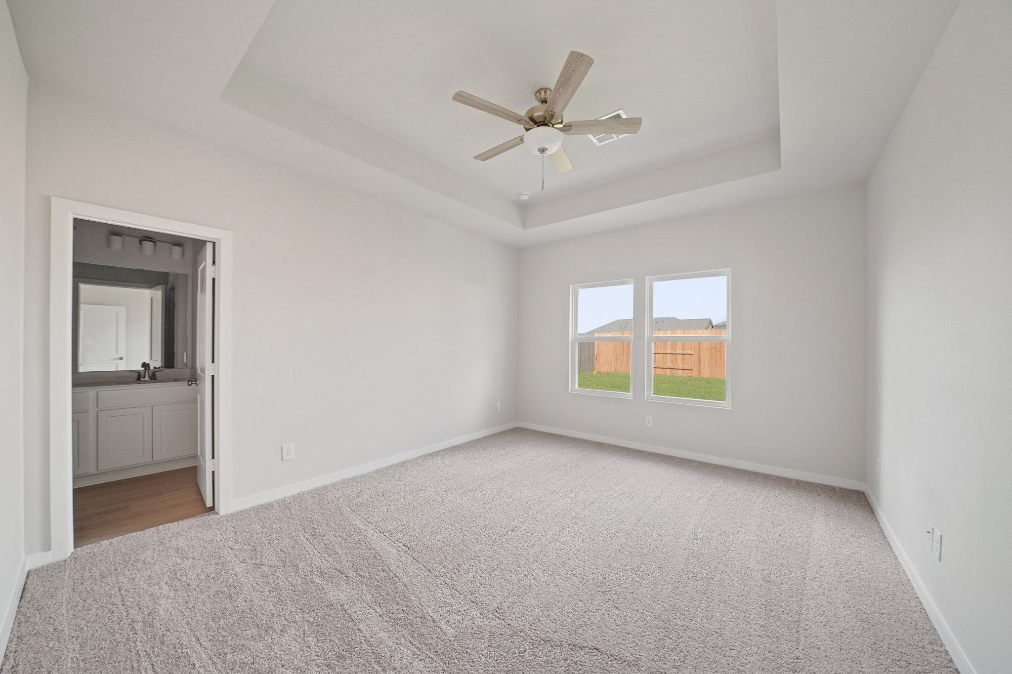 A room with a ceiling fan and a window.