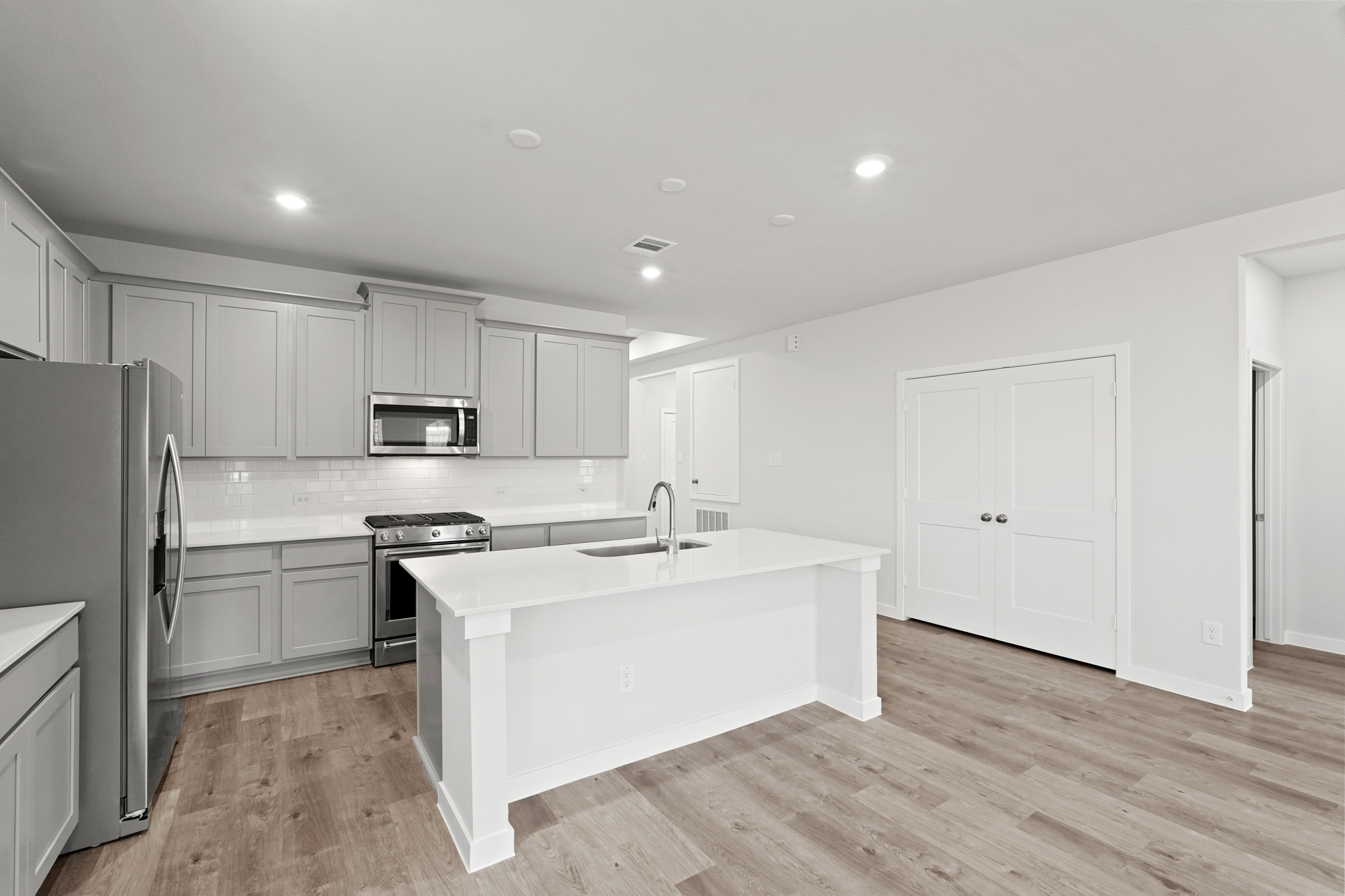 A kitchen with white cabinets.