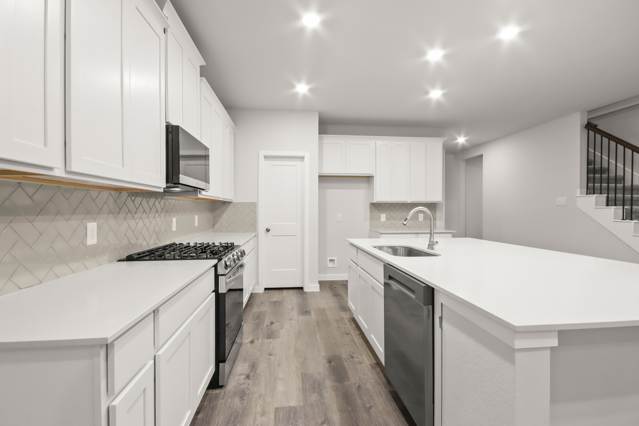 A kitchen with white cabinets.