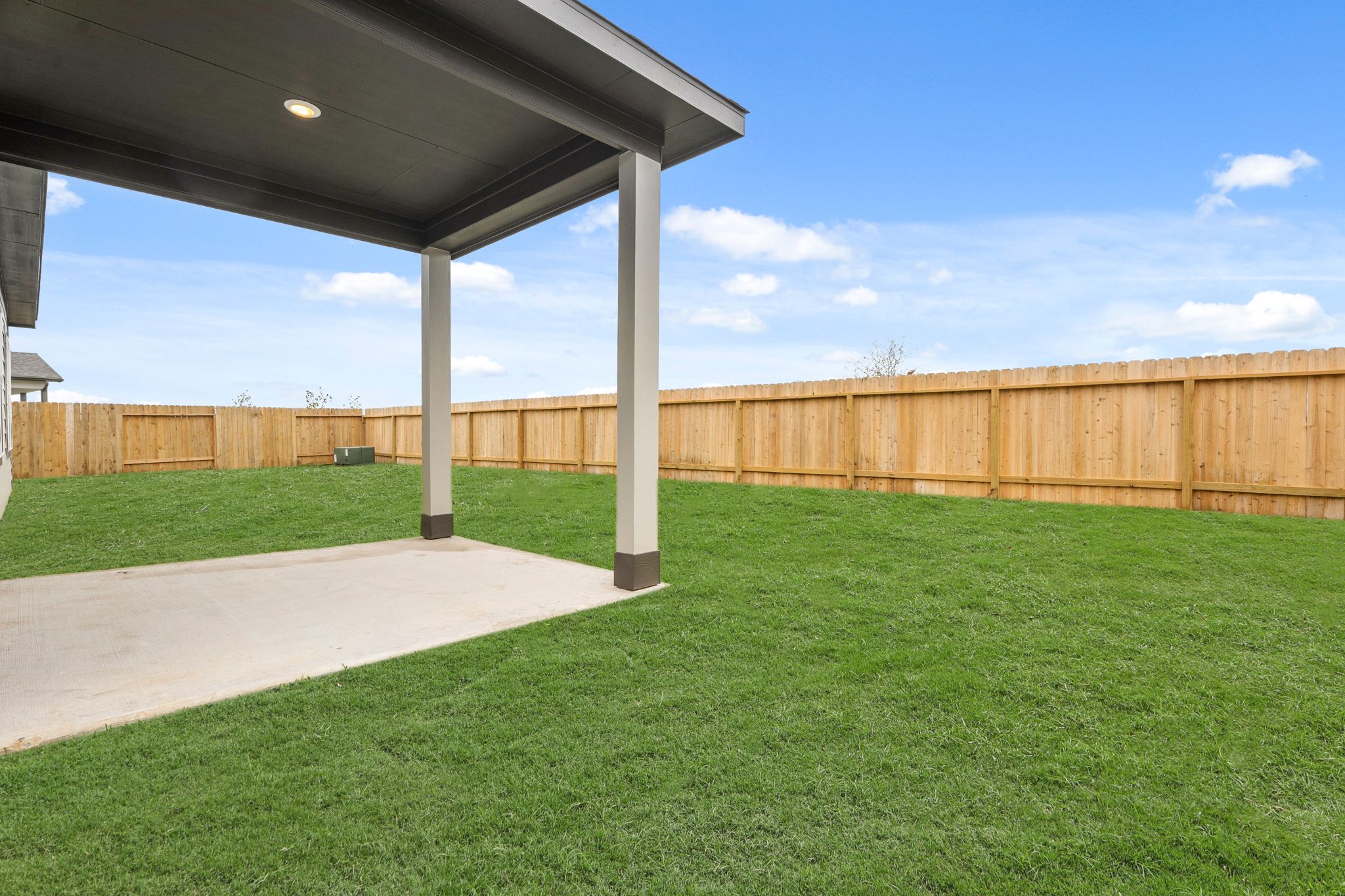 A grass yard with a fence.