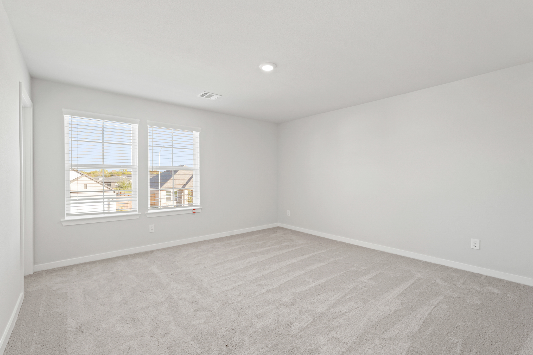 A room with a window and a carpet.