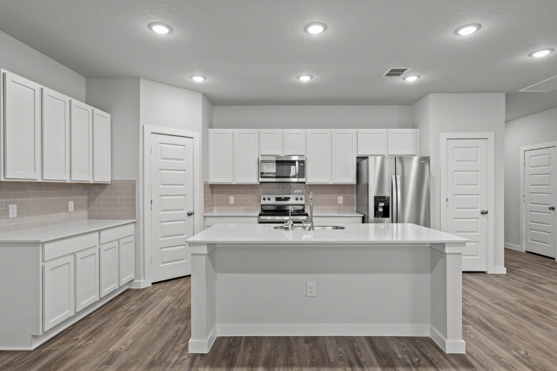 A kitchen with white cabinets.