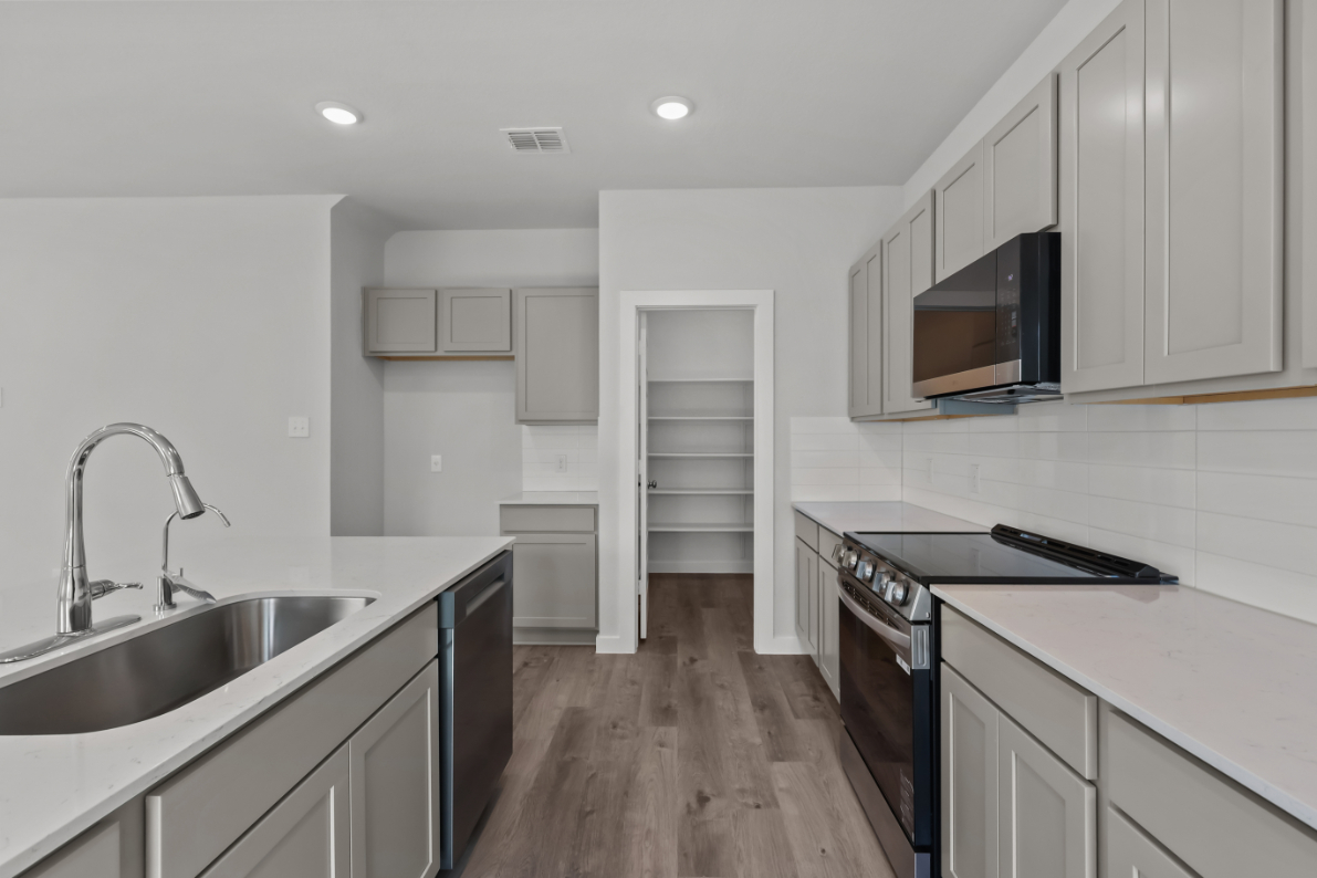 A kitchen with white cabinets.