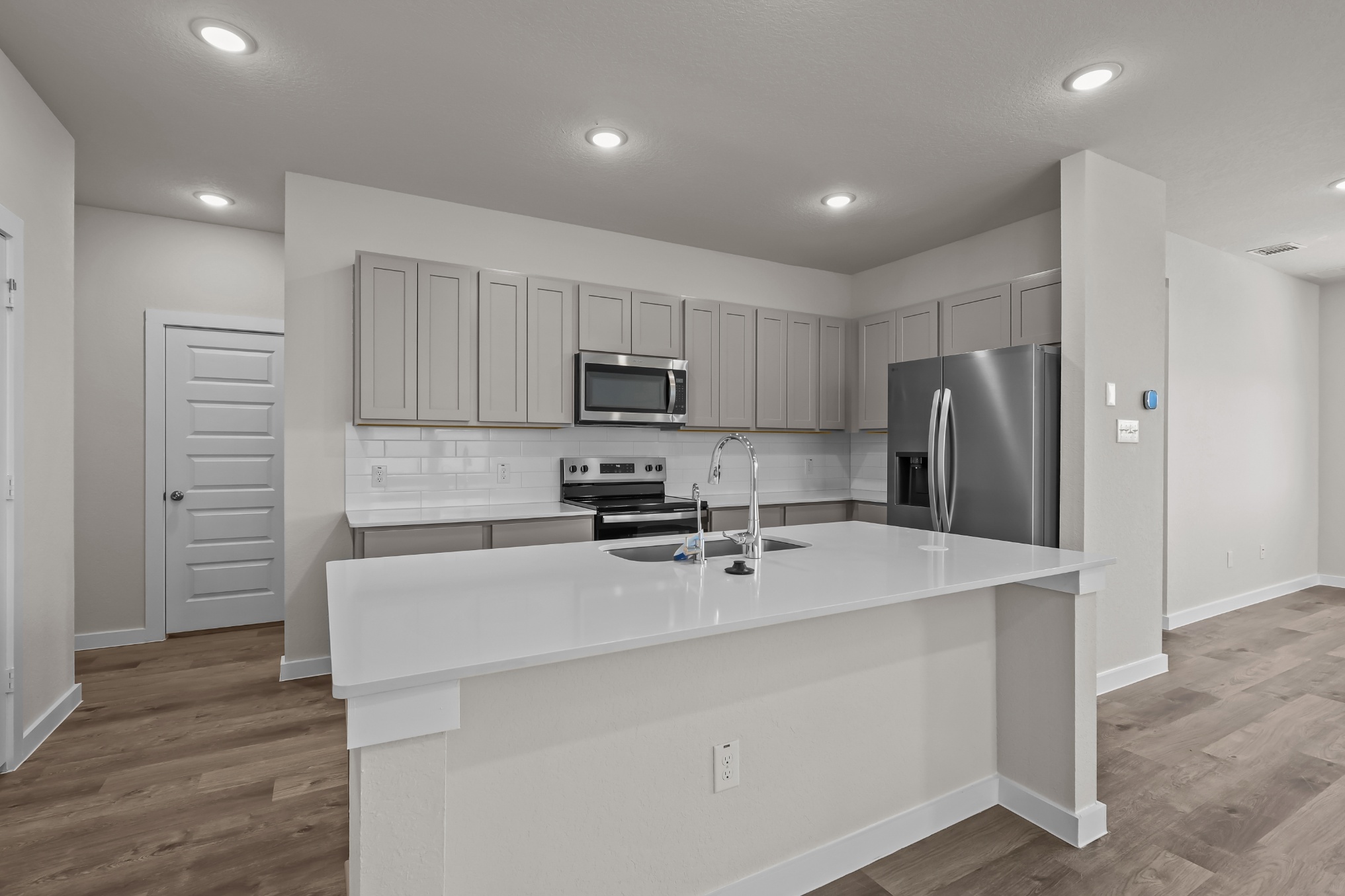 A kitchen with white cabinets.