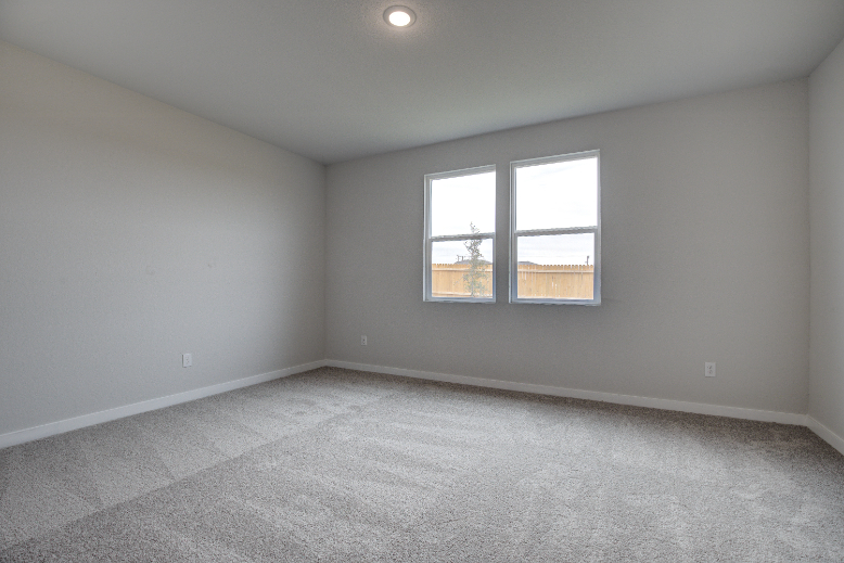A room with a window and a carpet.