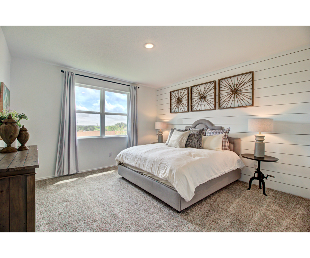 A bedroom with a bed and a window.