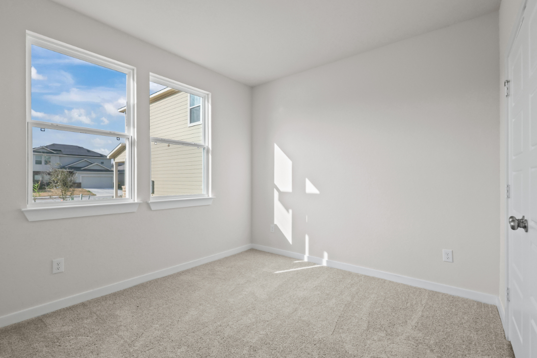 A room with a window and a door with a view of the ocean.